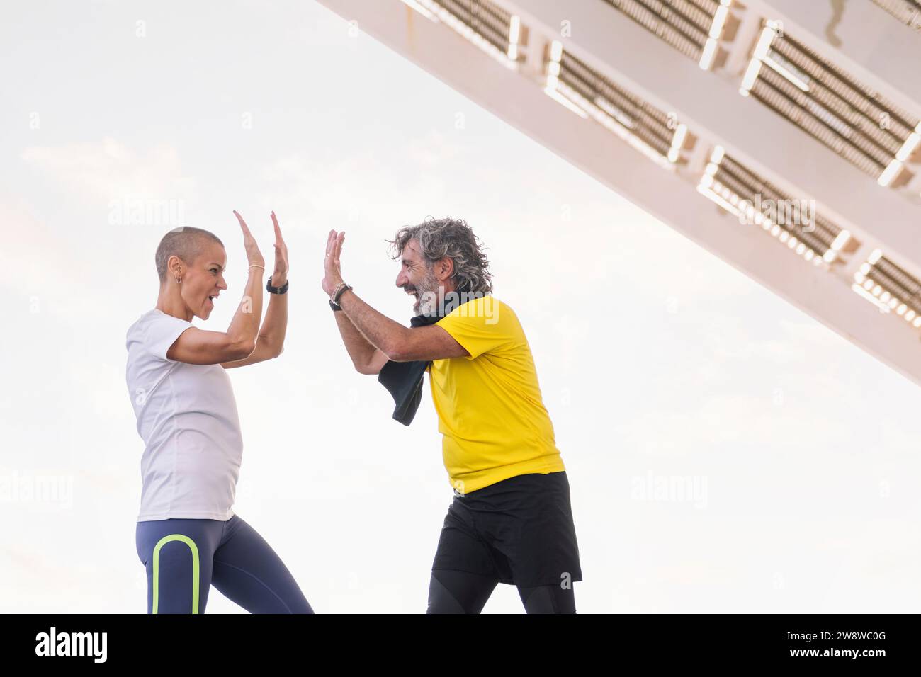 uomo anziano e allenatore sorridente felicemente alto cinque Foto Stock