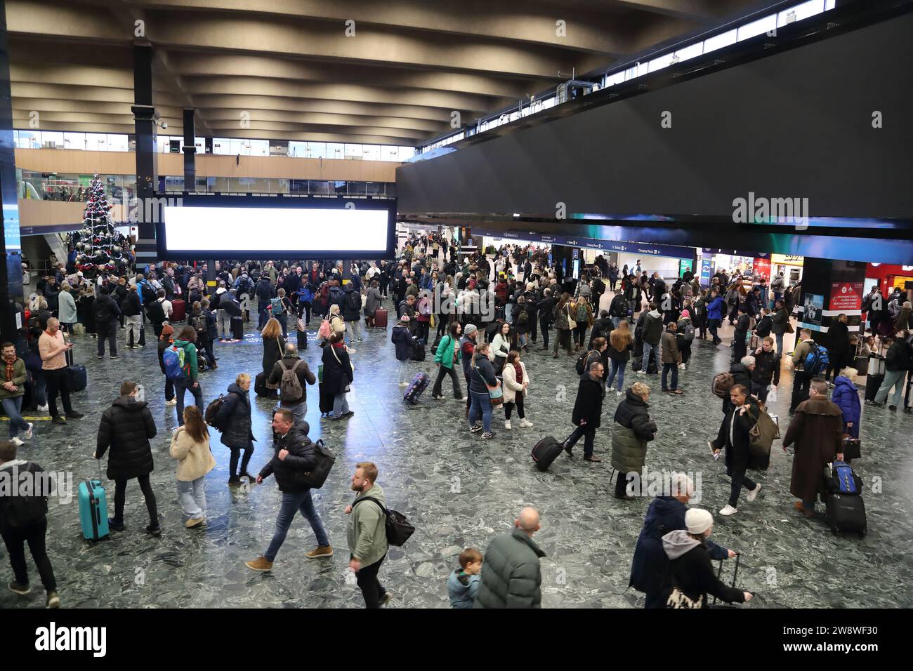 I viaggiatori che viaggiano presso l'affollata stazione di Euston diretti verso le loro destinazioni prima dei giorni festivi, Londra, Regno Unito Foto Stock