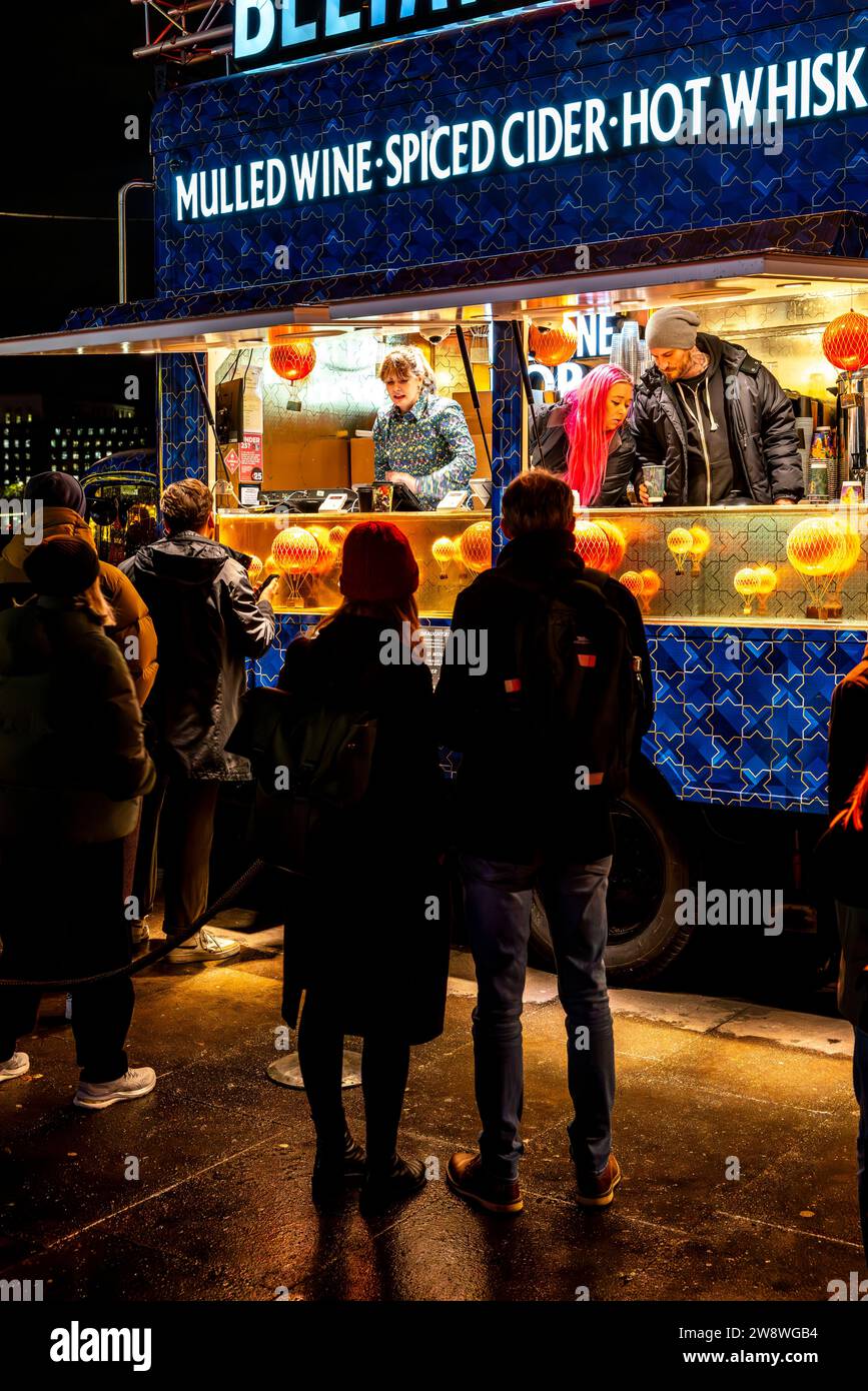 Persone che acquistano VIN brulé e sidro piccante ecc. da Un negozio/stand al Southbank Centre Winter Market, Londra, Regno Unito Foto Stock