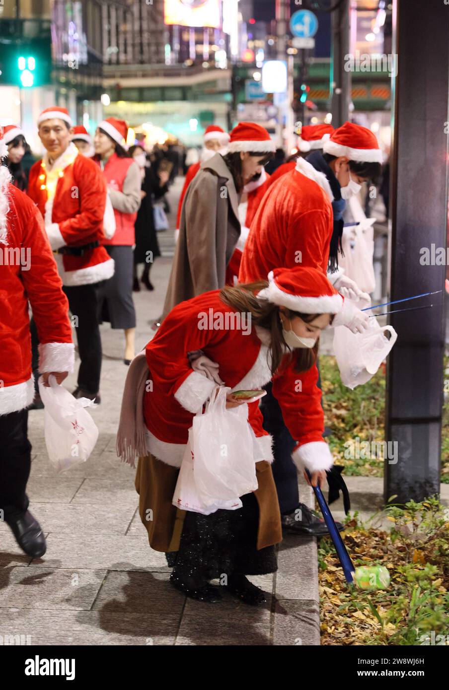 Tokyo, Giappone. 22 dicembre 2023. Circa 300 impiegati nei costumi di Babbo Natale raccolgono i garage nel quartiere degli affari Marunouchi di Tokyo per la sfilata di pulizia di Babbo Natale di venerdì 22 dicembre 2023. (Foto di Yoshio Tsunoda/AFLO) Foto Stock