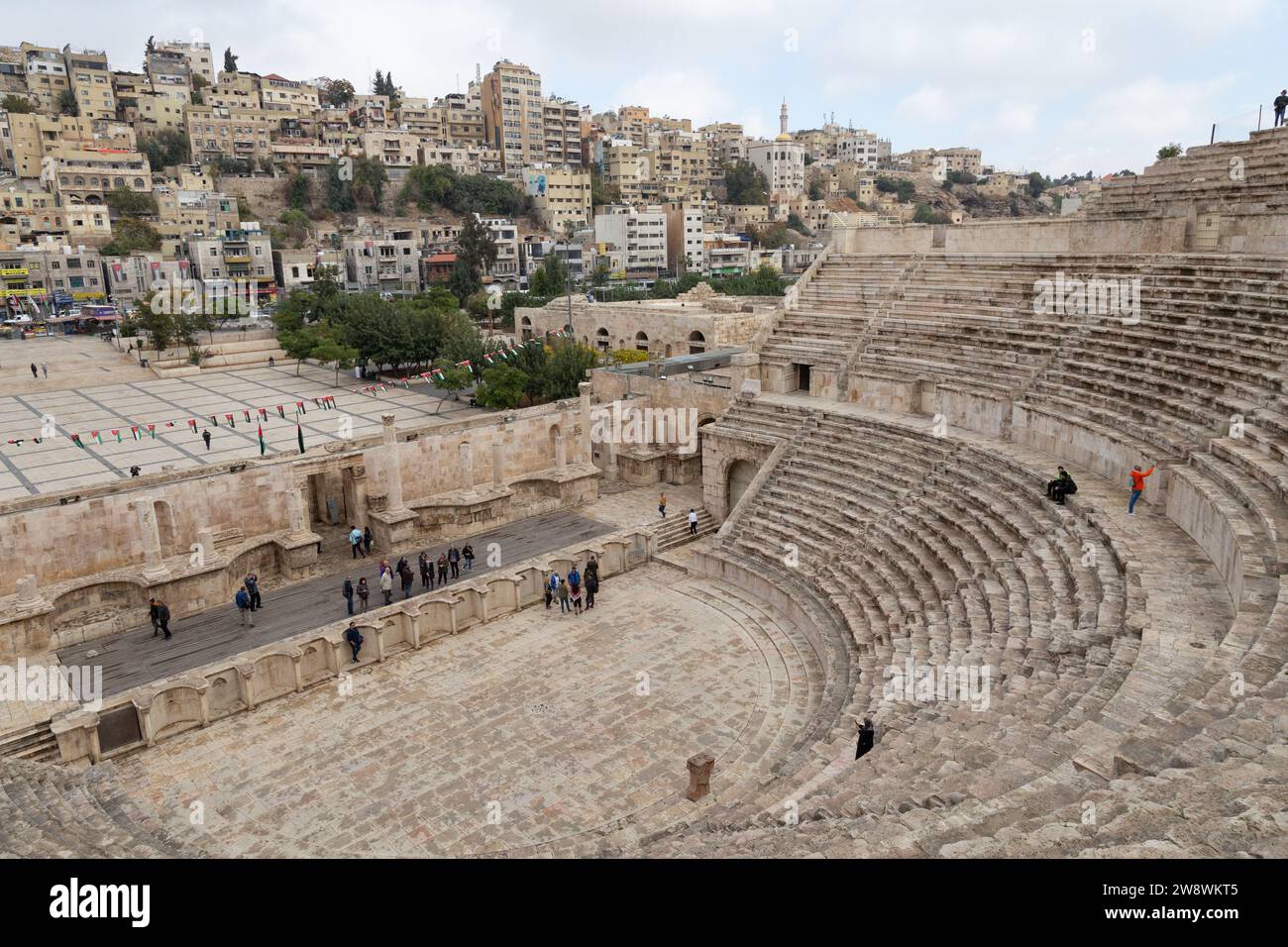 I turisti che visitano un teatro romano ad Amman durante la giornata invernale Foto Stock