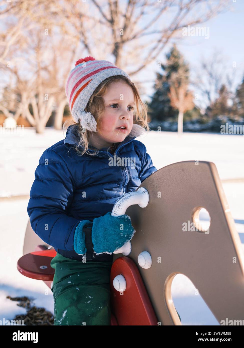 Bambino che indossa abiti invernali caldi che giocano sulla neve Foto Stock