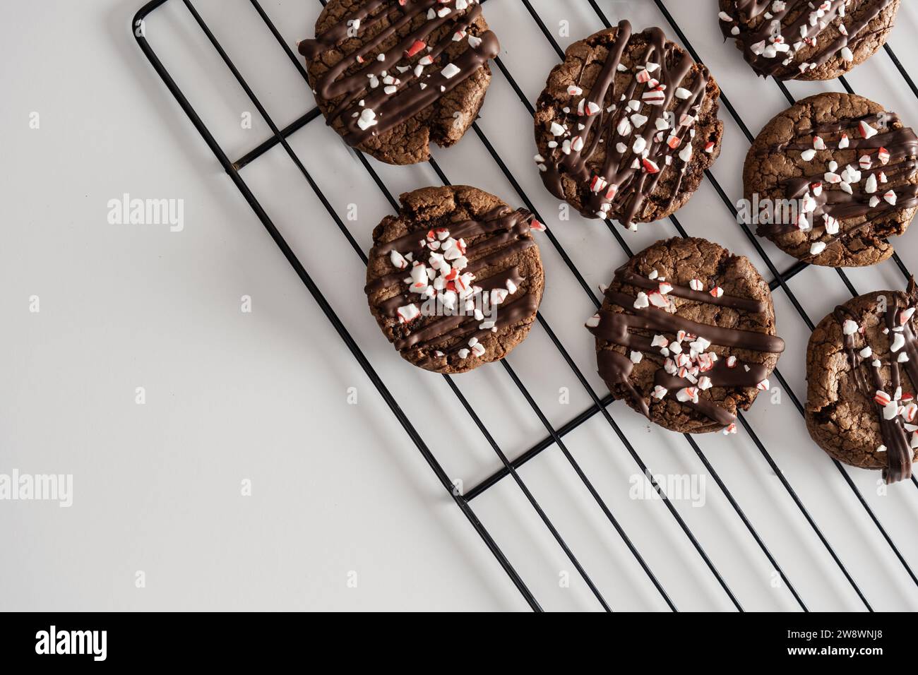 Biscotti al cioccolato con spolverini di menta piperita su griglia da forno. Foto Stock