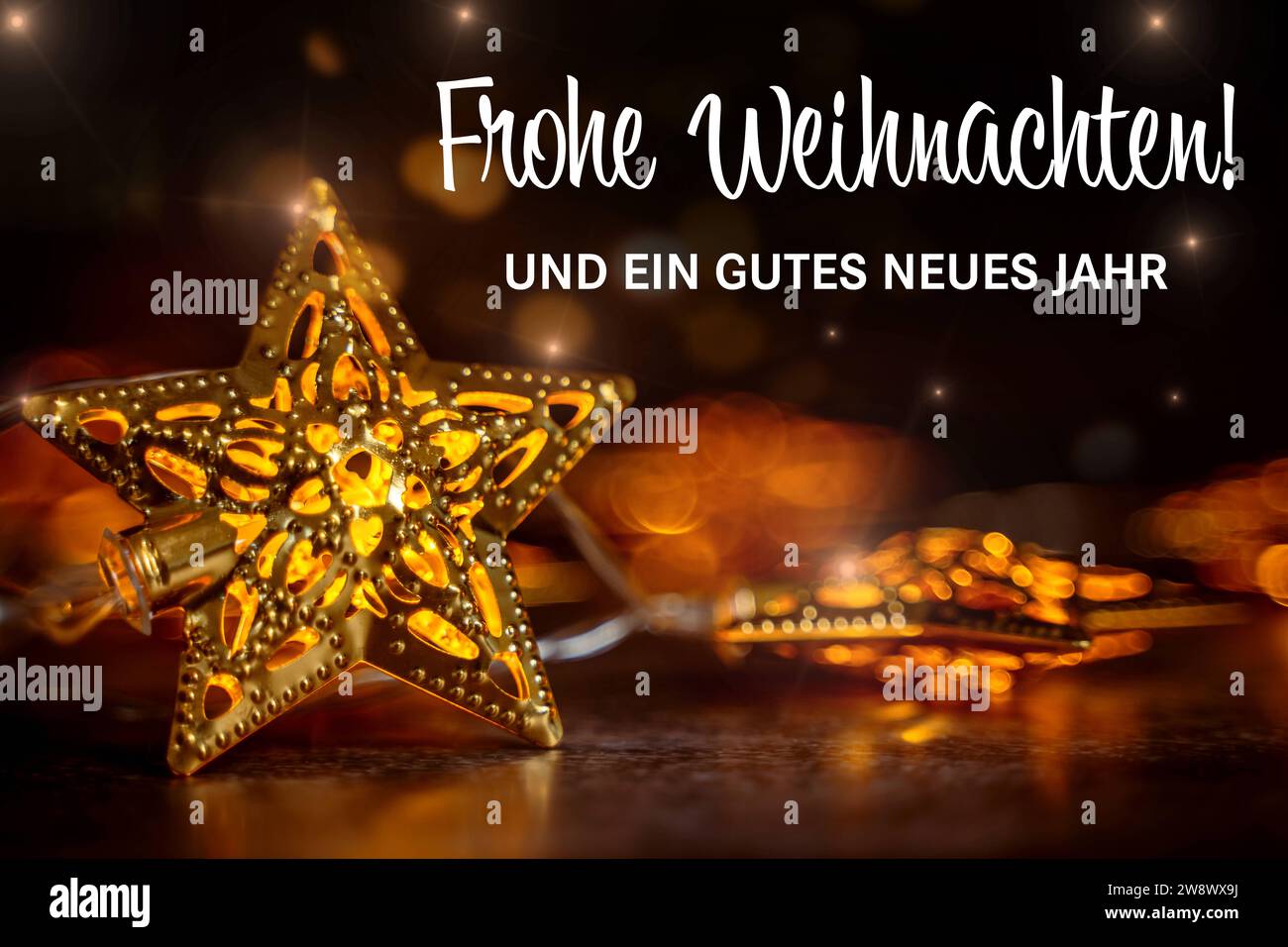22 dicembre 2023: Buon Natale e felice anno nuovo messaggio di benvenuto su un biglietto natalizio con stelle splendenti d'oro FOTOMONTAGE *** Frohe Weihnachten und ein gutes neues Jahr Gruß Schriftzug auf einer Weihnachtskarte mit goldenen leuchtenen Sternen FOTOMONTAGE Foto Stock