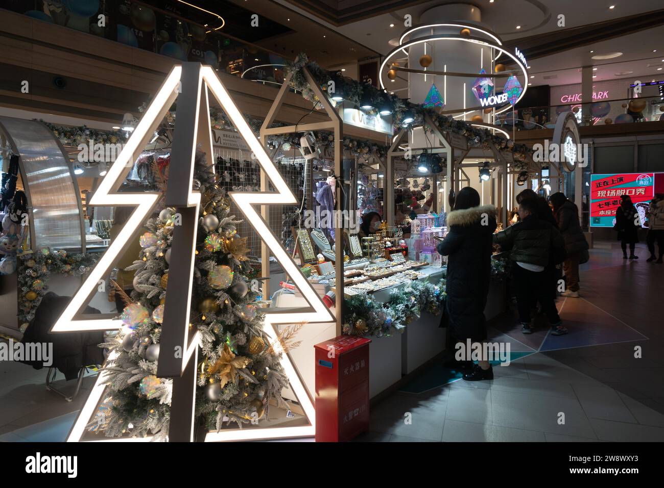 SHANGHAI, CINA - 22 DICEMBRE 2023 - i clienti fanno acquisti sotto l'albero di Natale all'evento natalizio Winter Wonder a Shanghai, Cina, dicembre Foto Stock