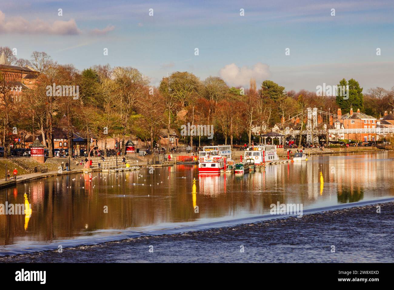 Guarda a monte attraverso la diga sul fiume Dee fino a showboats by the Groves. Chester, Cheshire, Inghilterra, Regno Unito, Gran Bretagna Foto Stock