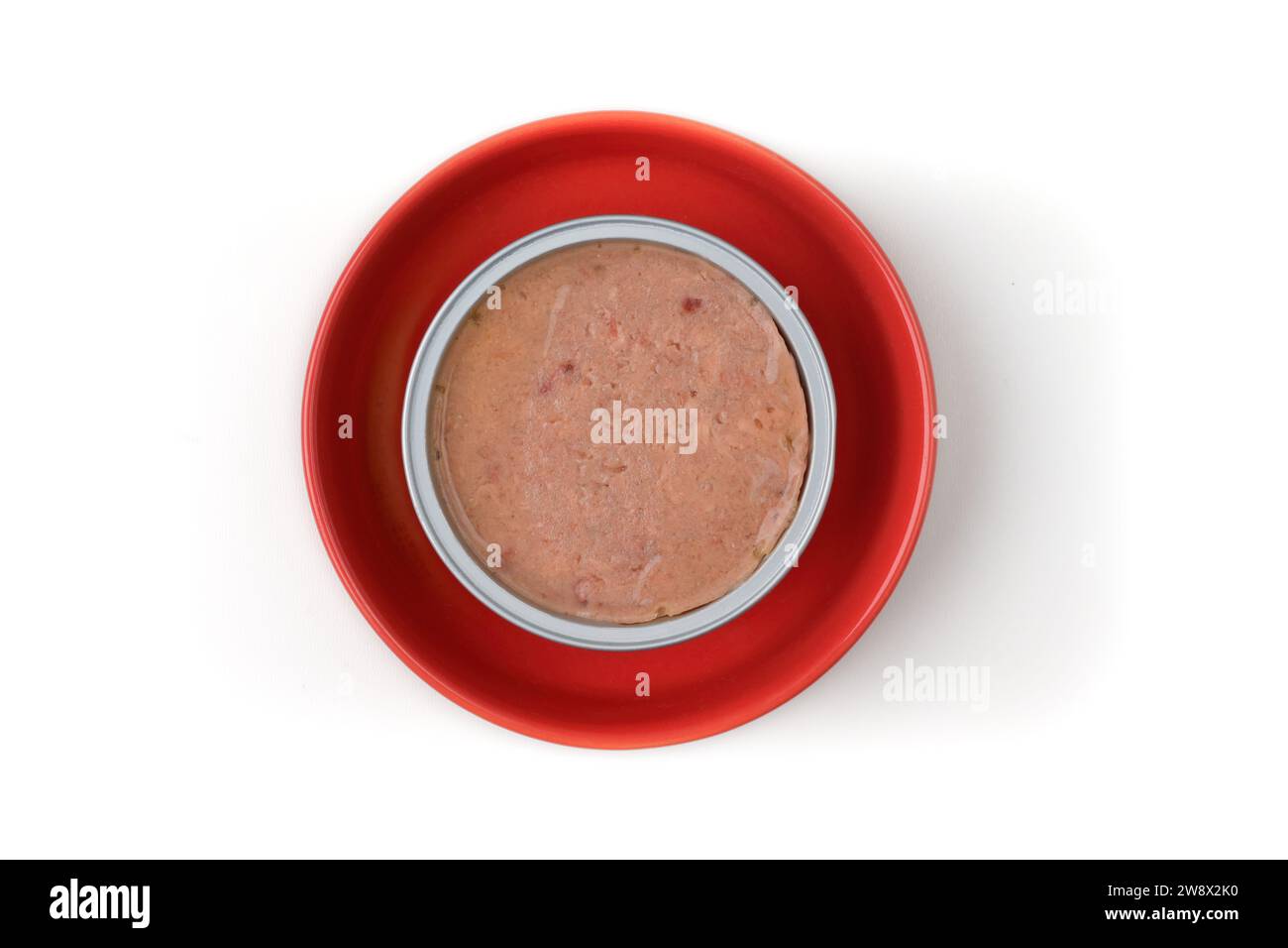 Aprire la confezione di alimenti umidi per animali domestici su un piatto rosso, visto direttamente dall'alto. Isolato su sfondo bianco. Foto Stock