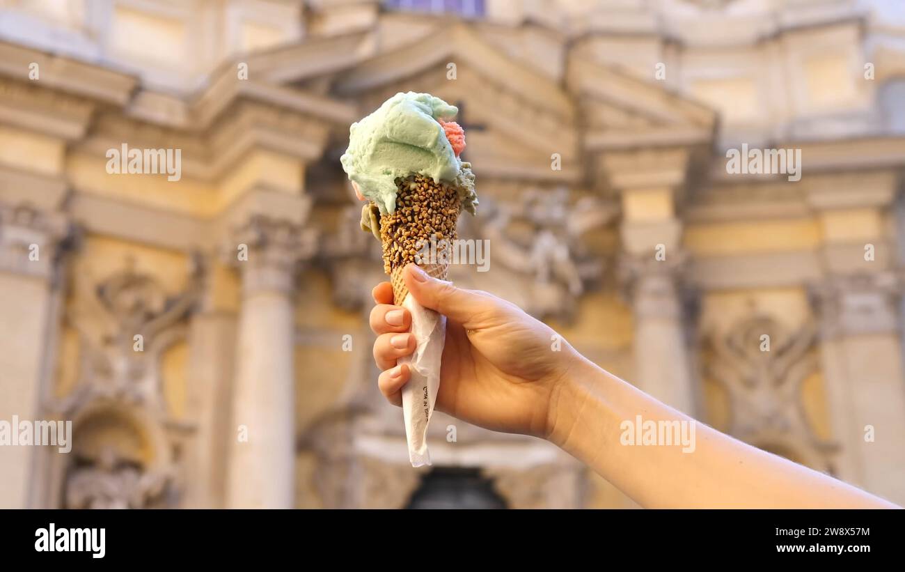 Piatto italiano - gelato italiano mais in mano - gelato italiano in mano donna. Donna che tiene a mano un cono gelato italiano Foto Stock