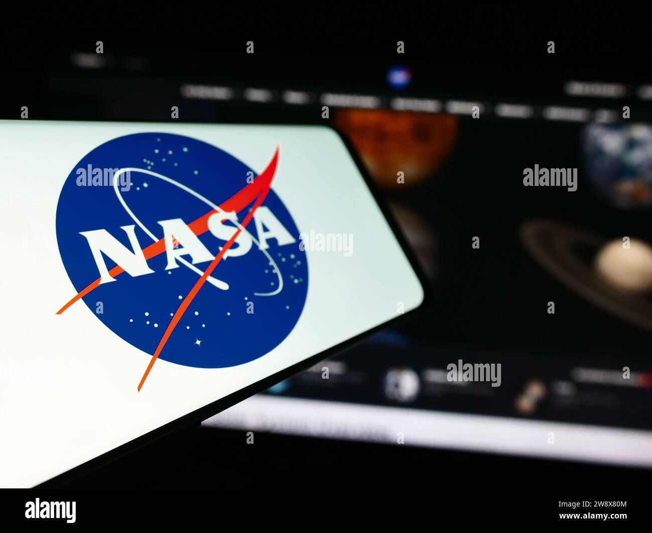 Telefono cellulare con logo dell'American National Aeronautics and Space Administration (NASA) davanti al sito web. Mettere a fuoco sul lato sinistro del display del telefono. Foto Stock