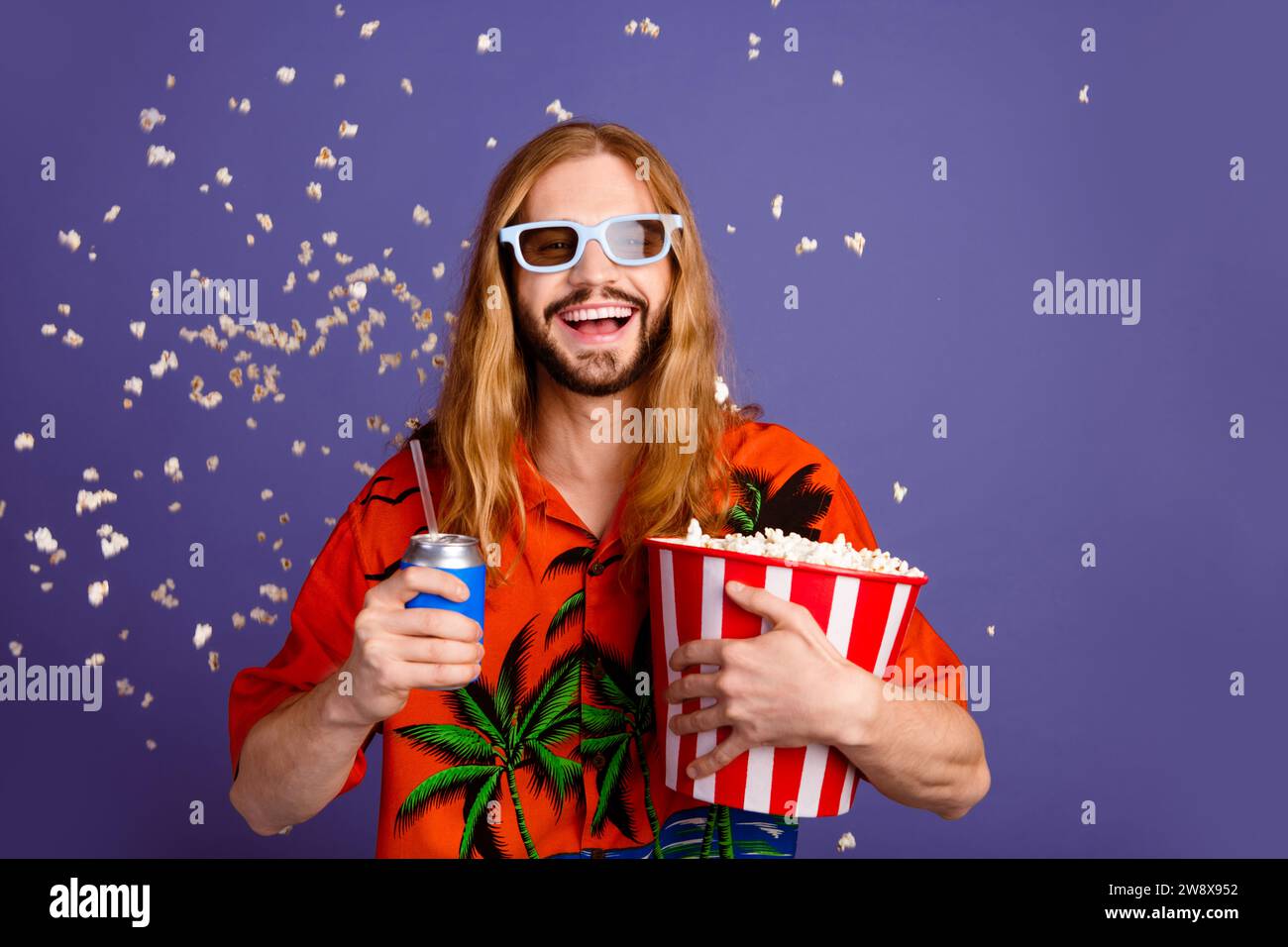 Ritratto di un'allegra camicia stampata vestita da uomo in occhiali 3d con pop corn soda che fissa gli effetti visivi isolati su sfondo viola Foto Stock