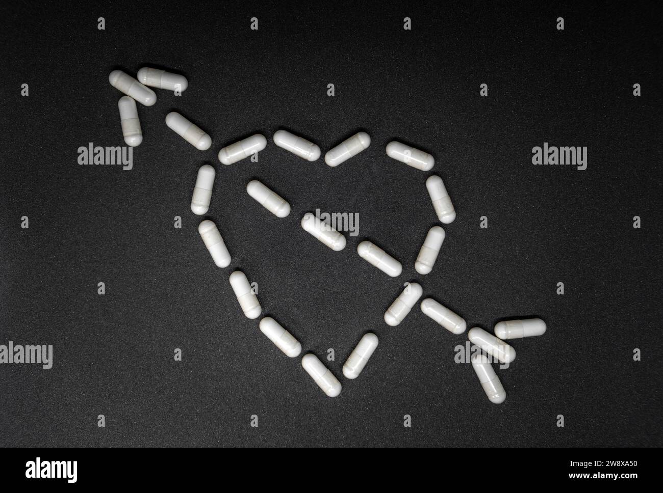 Cuore con freccia fatto di pillole concetto Foto Stock