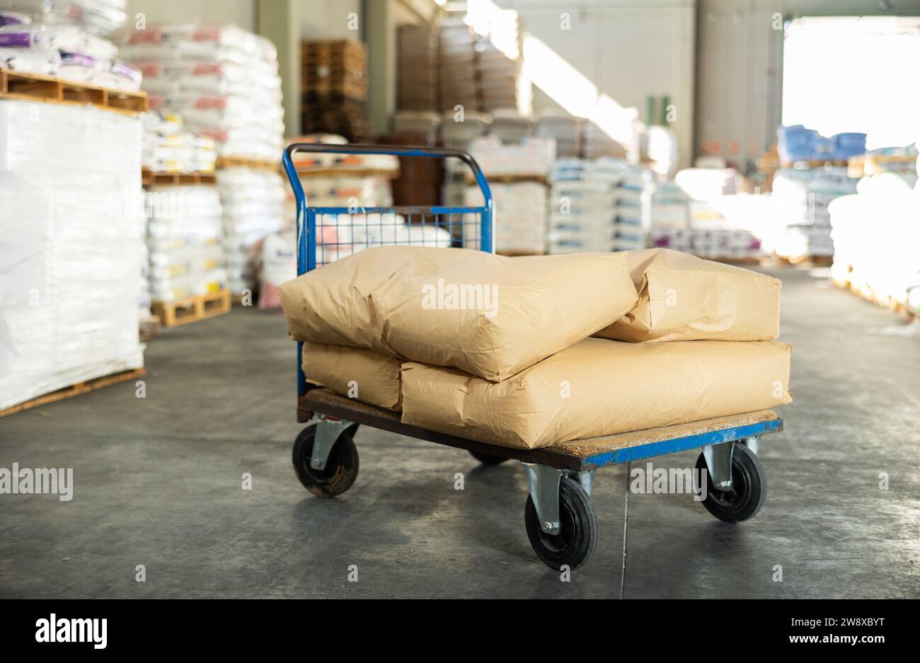 I sacchetti sono impilati l'uno sopra l'altro e si trovano in pile nel magazzino di un negozio di materiali da costruzione. Foto Stock