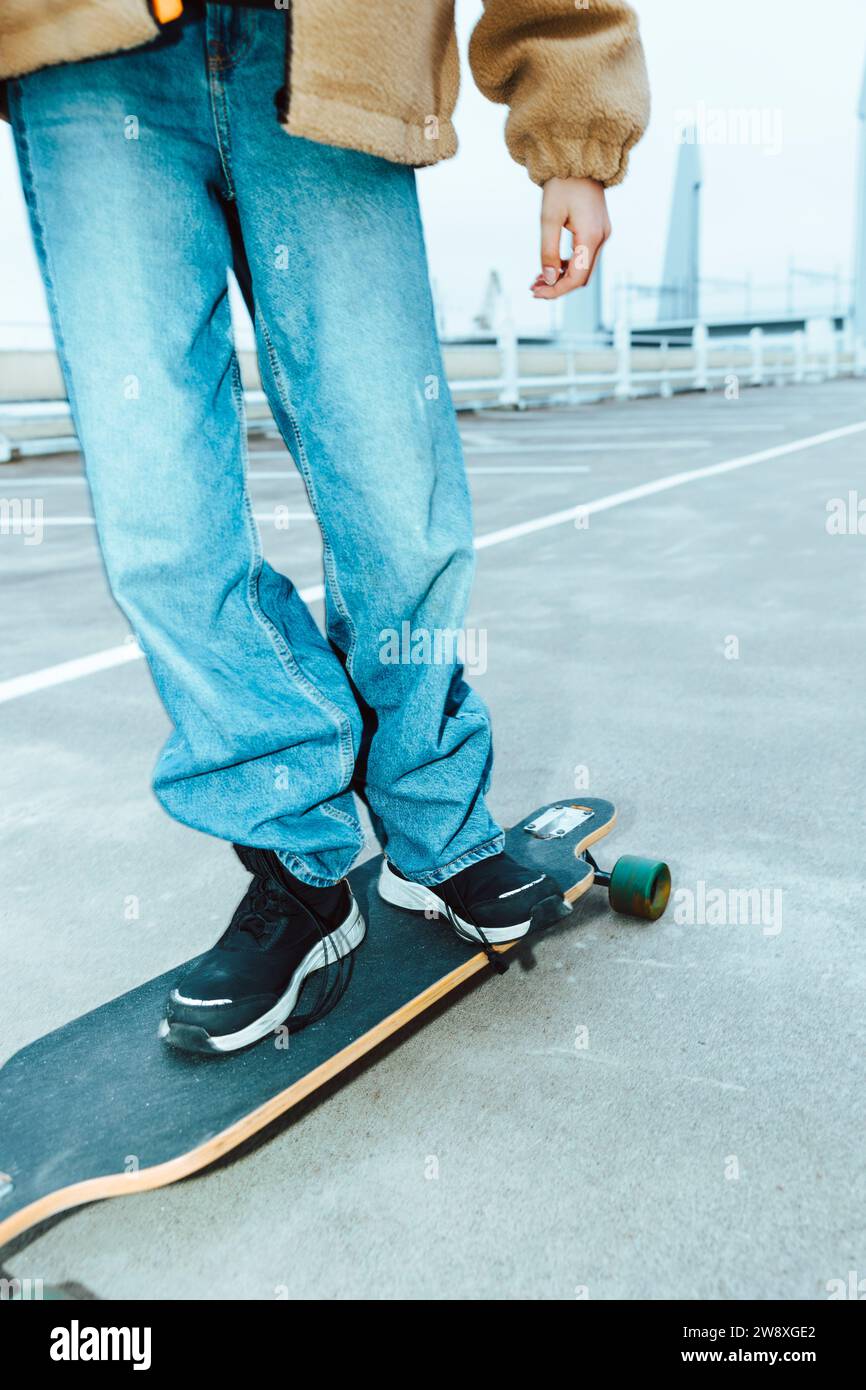 Sezione bassa di skateboard femminile sulla strada durante il fine settimana Foto Stock