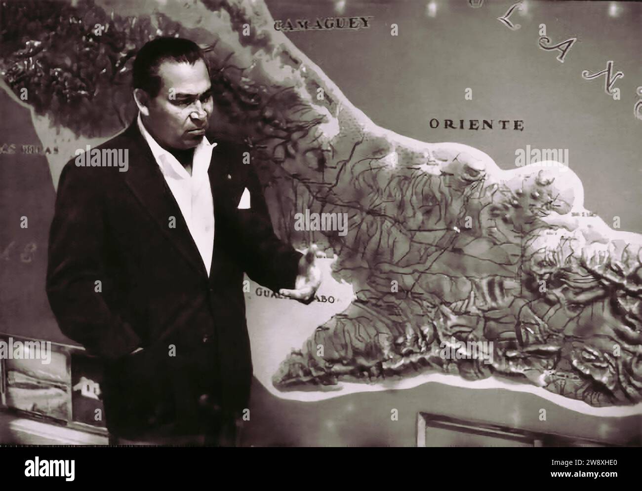 Il dittatore cubano Fulgencio Batista nel marzo 1957, in piedi accanto a una mappa delle montagne della Sierra Maestra dove furono trattenuti i ribelli di Fidel Castro. (didascalia originale, non scritta dal collaboratore) Foto Stock