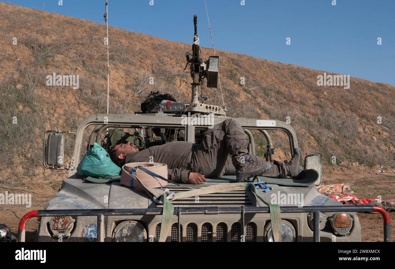 Israele meridionale, Israele. 22 dicembre 2023. Un soldato di fanteria di riserva israeliana dell'IDF che cattura alcuni in cima al cofano di un Humvee dopo essere tornato in un'area di sosta israeliana meridionale vicino al confine con la Striscia di Gaza il 22 dicembre 203. Gli Stati Uniti chiedono a Israele di essere più precisi nei suoi attacchi contro il terrorista di Hamas nell'attuale guerra che è al terzo mese. Foto di Jim Hollander/UPI Credit: UPI/Alamy Live News Foto Stock