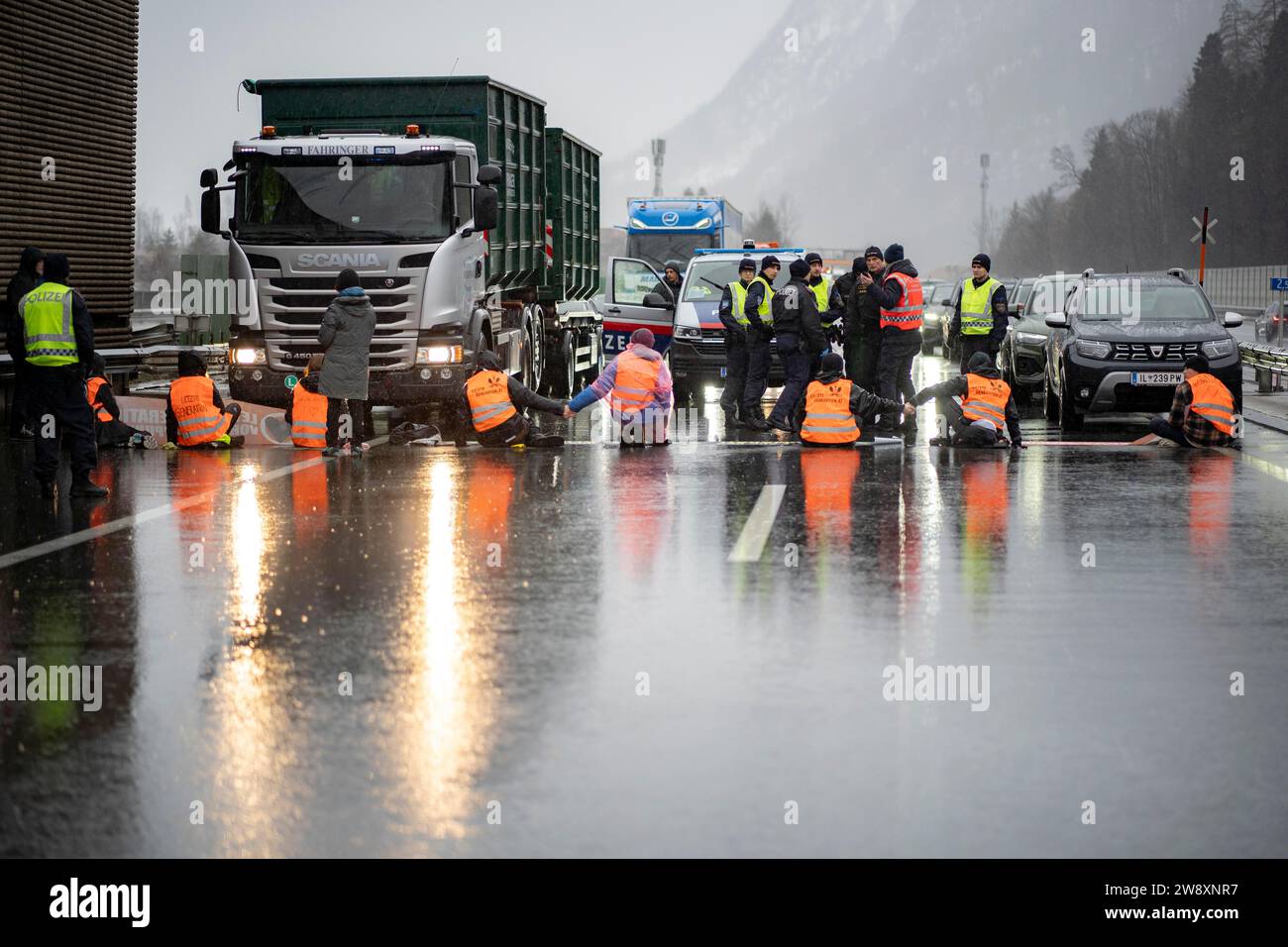 Kufstein, Tirolo, Austria. 22 dicembre 2023. Attivista per il clima dell'Austria di ultima generazione e della Germania di ultima generazione si incollano alla superstrada A12 Inntal Autobahn vicino al confine tra Austria e Germania. L'attivista esige una legislazione più rispettosa del clima da parte degli attuali governi. (Immagine di credito: © Andreas Stroh/ZUMA Press Wire) SOLO USO EDITORIALE! Non per USO commerciale! Foto Stock