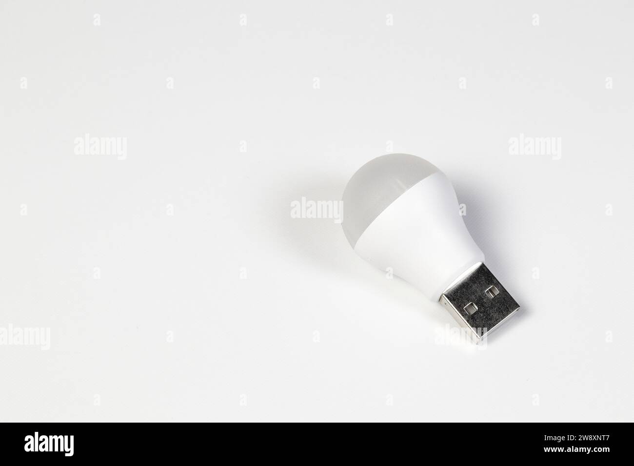 Lampadina a LED bianca con connettore tipo USB tipo A per il risparmio energetico isolata su sfondo bianco. Foto Stock