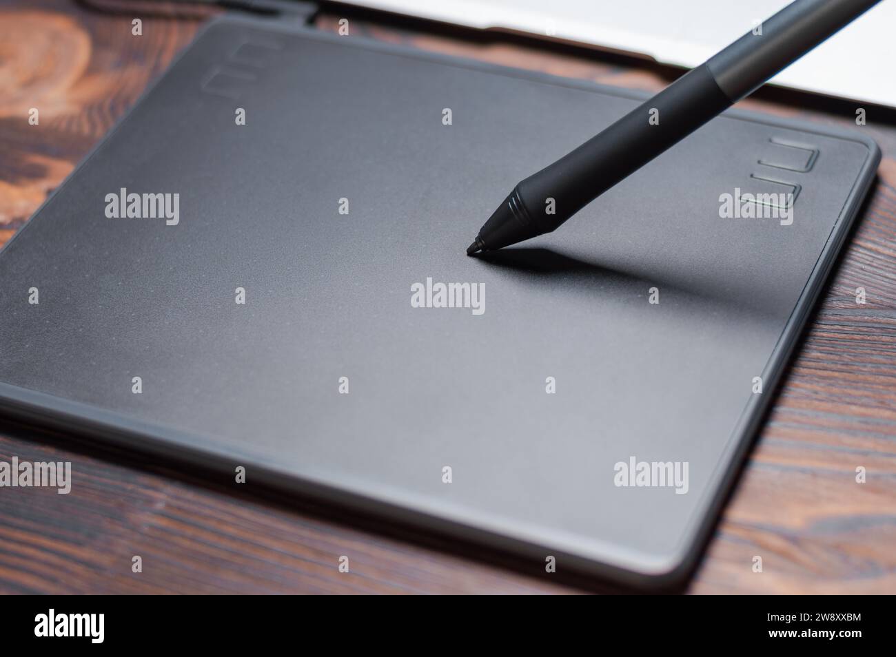 Immagine di una tavoletta grafica, uno stilo e un laptop su un tavolo di legno. Ambiente di lavoro di design. Freelance. Ritocco. Concetto IT. Supporti misti Foto Stock