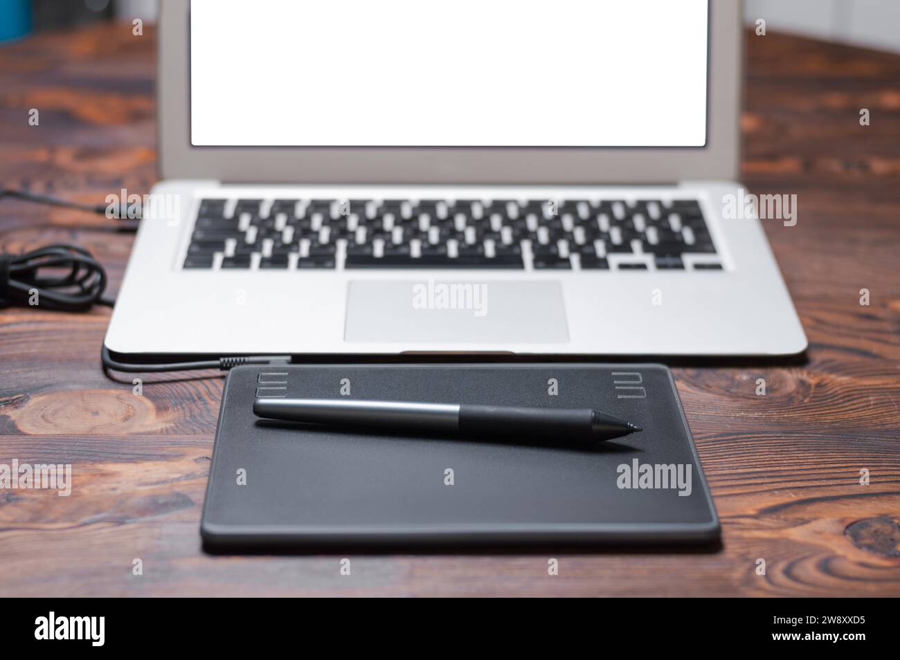 Immagine di una tavoletta grafica, uno stilo e un laptop su un tavolo di legno. Ambiente di lavoro di design. Freelance. Ritocco. Concetto IT. Supporti misti Foto Stock