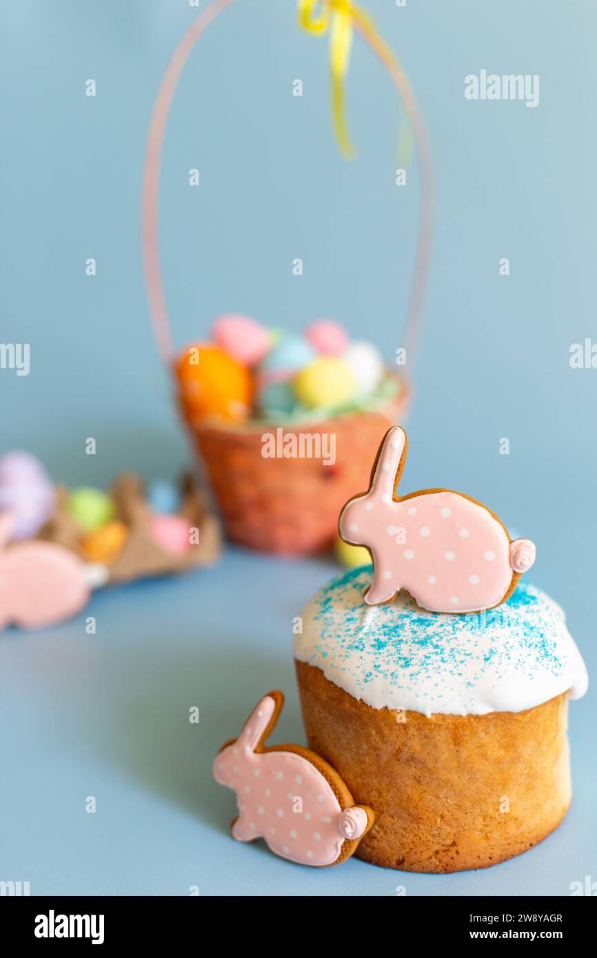 Natura morta di Pasqua con due pan di zenzero rosa sotto forma di coniglio su una torta pasquale Foto Stock