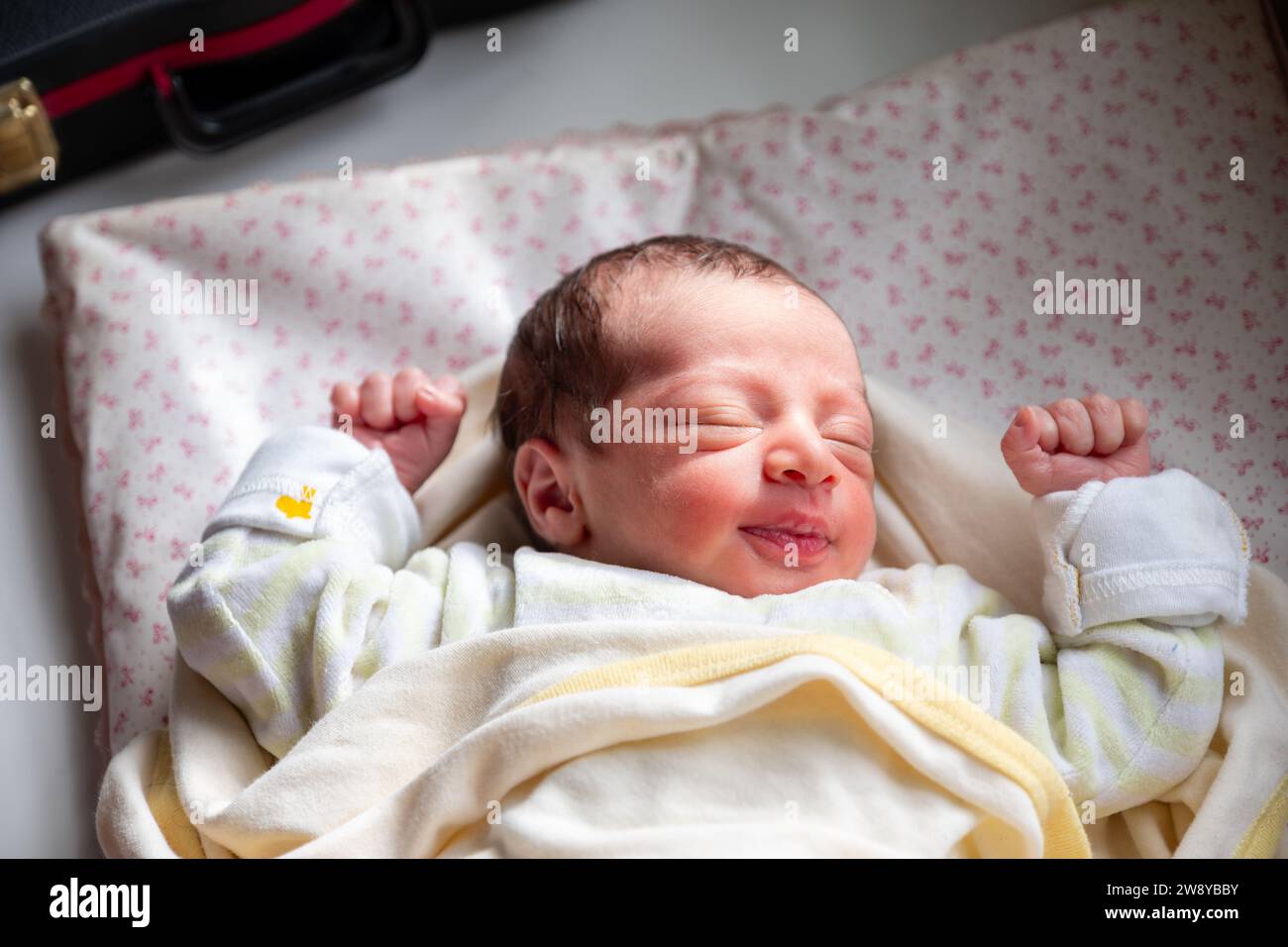 Un nuovo membro della famiglia reagisce con la luce solare e il sorriso sul viso, inizia un nuovo viaggio e una nuova storia Foto Stock