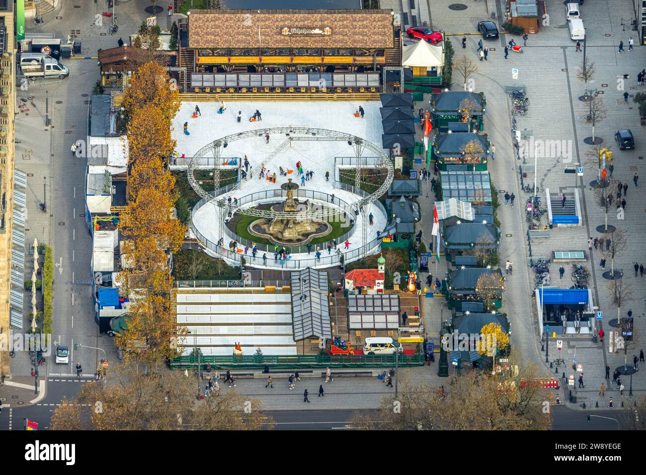 Vista aerea, pattinaggio sul ghiaccio sulla pista di pattinaggio Corneliusplatz nella zona pedonale di Königsallee, Alm di Füchschen, circondata da alberi decidui autunnali, cit Foto Stock