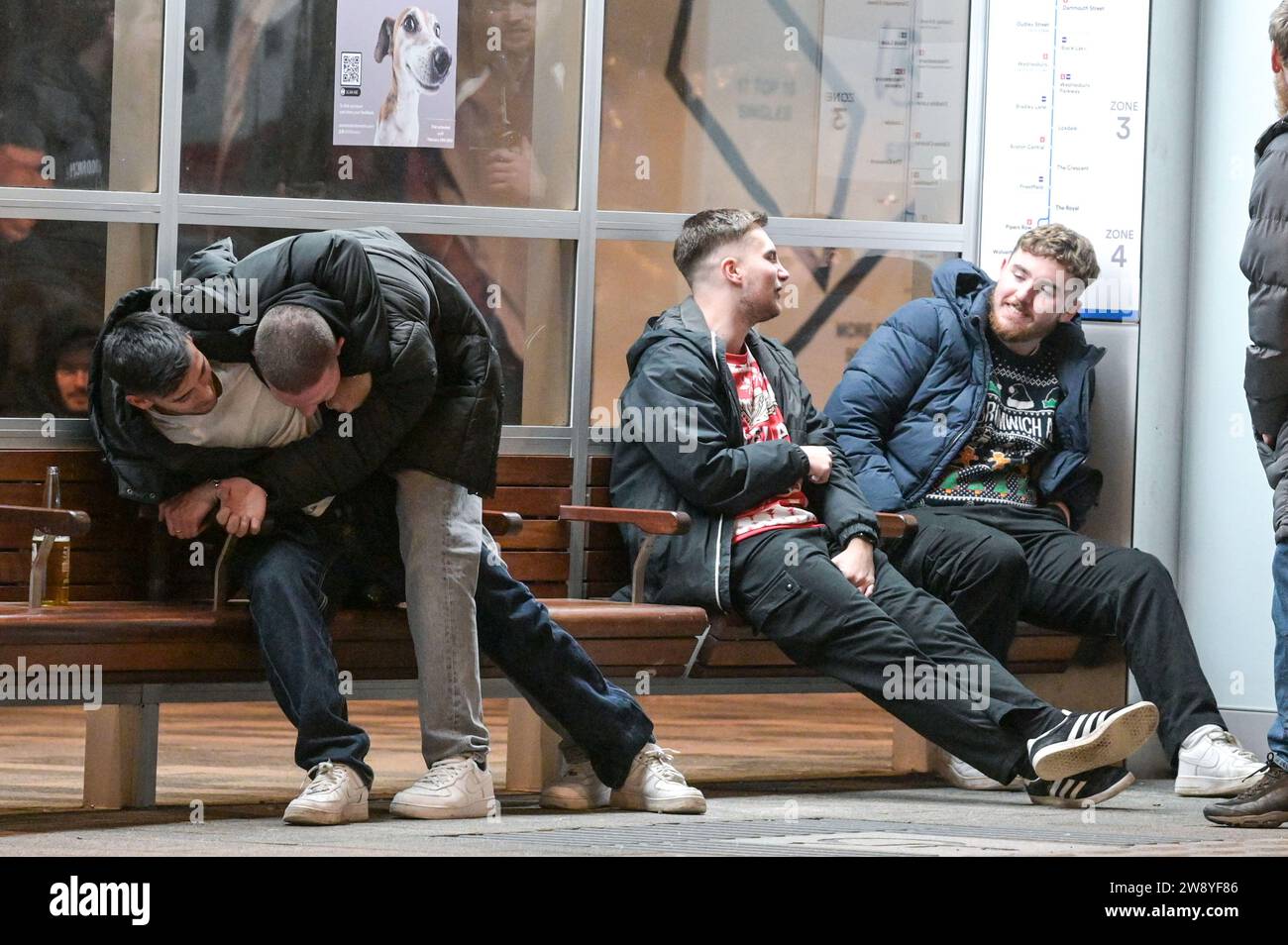Birmingham 22 dicembre 2023 - Friends Tussle in Broad Street a Birmingham il Black Eye Friday - i rivenditori sono andati a Birmingham il Mad Friday, che prende anche il nome di Black Eye Friday. I gruppi di lavoro erano in pieno svolgimento mentre le aziende chiudevano per le vacanze di Natale. Si è visto molto passeggiare per il centro della città con un enorme bicchiere di birra da mercato tedesco e molti indossavano cappelli di Babbo Natale. Un gruppo di 3 compagni di lavoro si è recato in un ristorante messicano per le loro attività e due hanno indossato abiti messicani con il loro collega che si è attaccato a un tradizionale cappello di Babbo Natale. Alcuni amici sono stati anche avvistati su Broad Street con un tussl Foto Stock