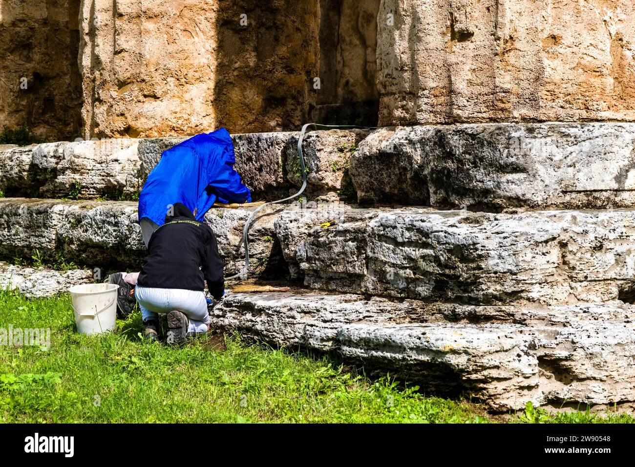 Ristoratori che lavorano al secondo Tempio di Hera, appartenenti alle rovine di Paestum, un'importante antica città greca sulla costa del Mar Tirreno. Foto Stock