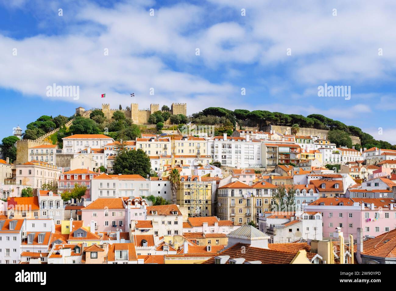 Vista sui tetti rossi delle vecchie case verso il castello di Sao Jorge sulla cima della collina. Lisbona, Portogallo, Europa. Foto Stock