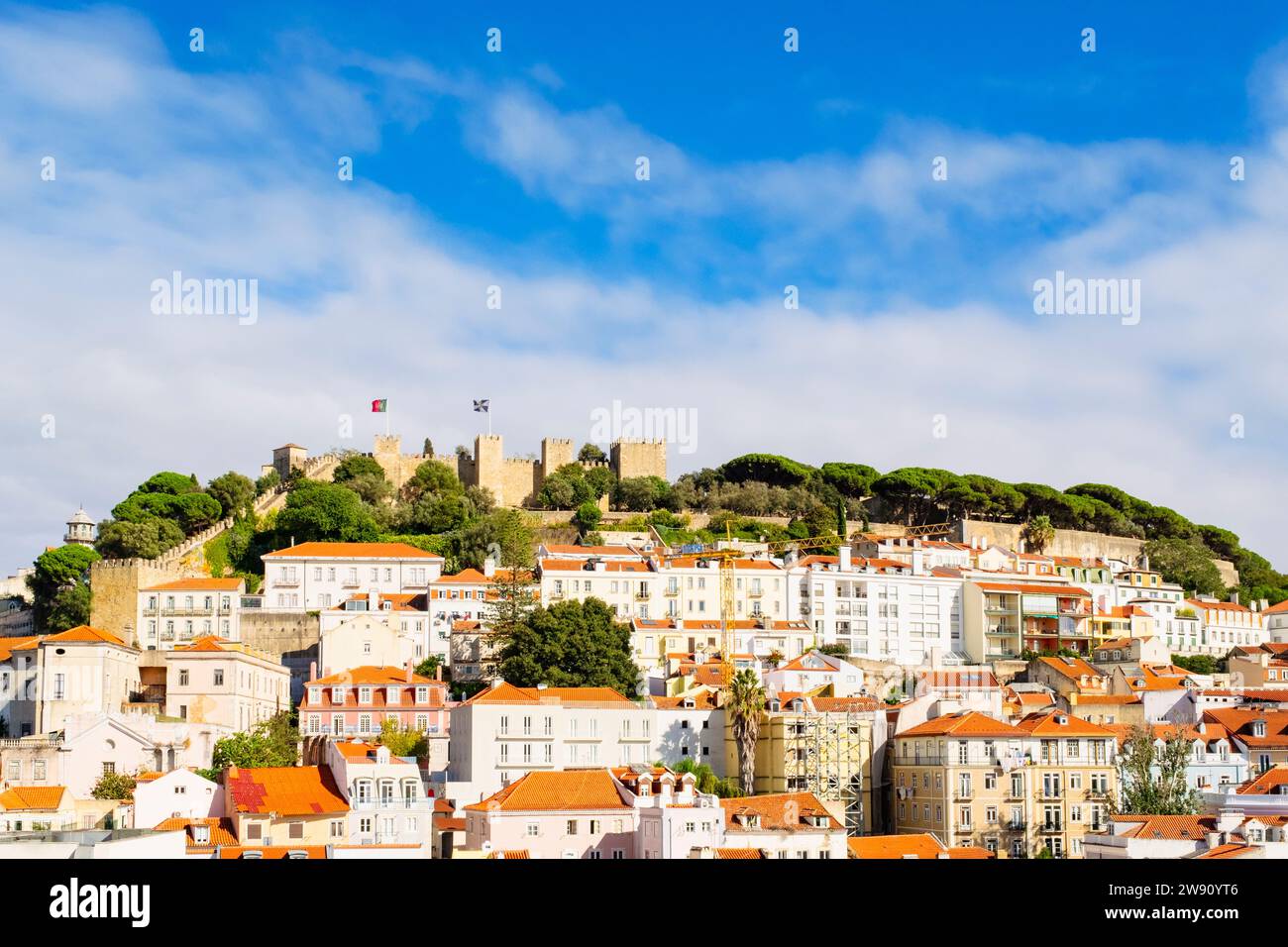 Vista sui tetti rossi delle vecchie case verso il castello di Sao Jorge sulla cima della collina. Lisbona, Portogallo, Europa. Foto Stock