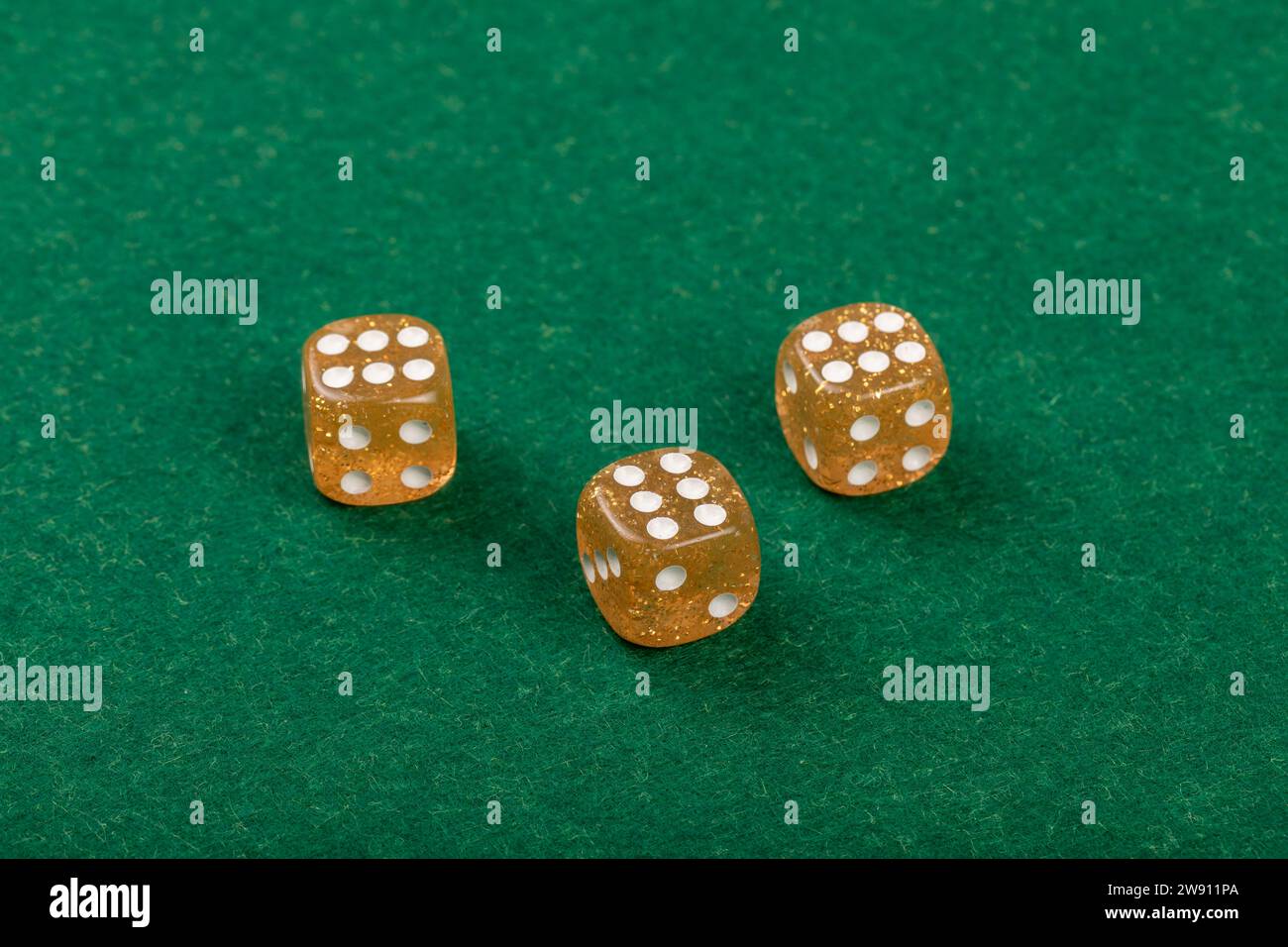 Tavolo casinò con tre dadi gialli sul Green Velvet per giochi e gioco d'azzardo Foto Stock