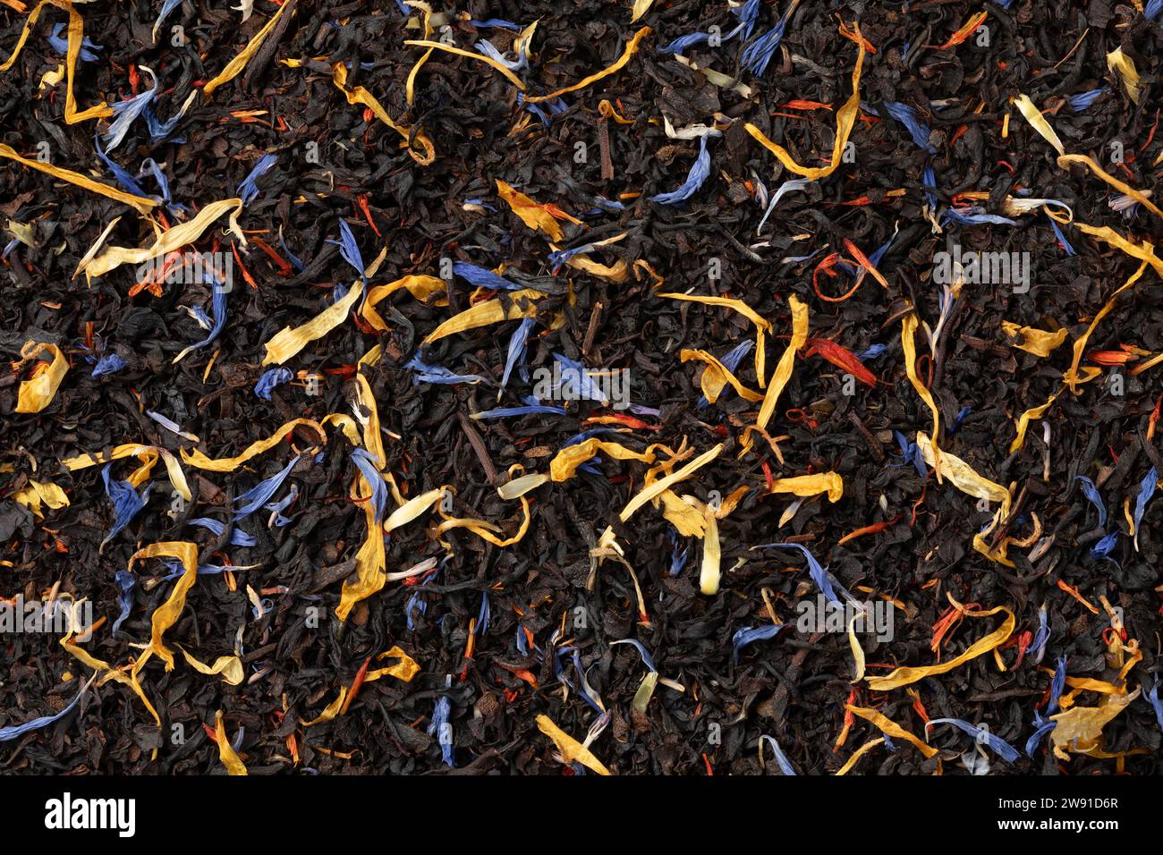 Tè nero con foglie di fiori essiccate a cornice intera come sfondo da vicino Foto Stock