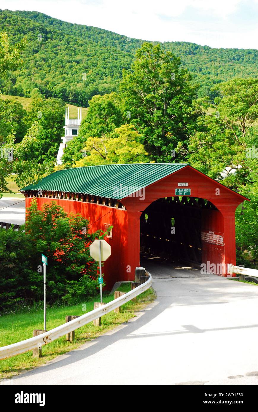 Il ponte coperto di Arlington nel Vermont rurale conduce a una piccola città e a una chiesa campanile bianca Foto Stock