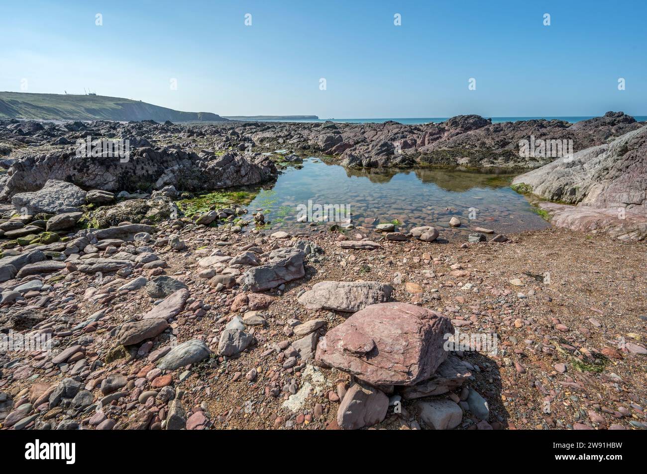 Calme piscine rocciose intrappolate tra le antiche rocce sulla Freshwater West Beach Pembrokeshire Foto Stock