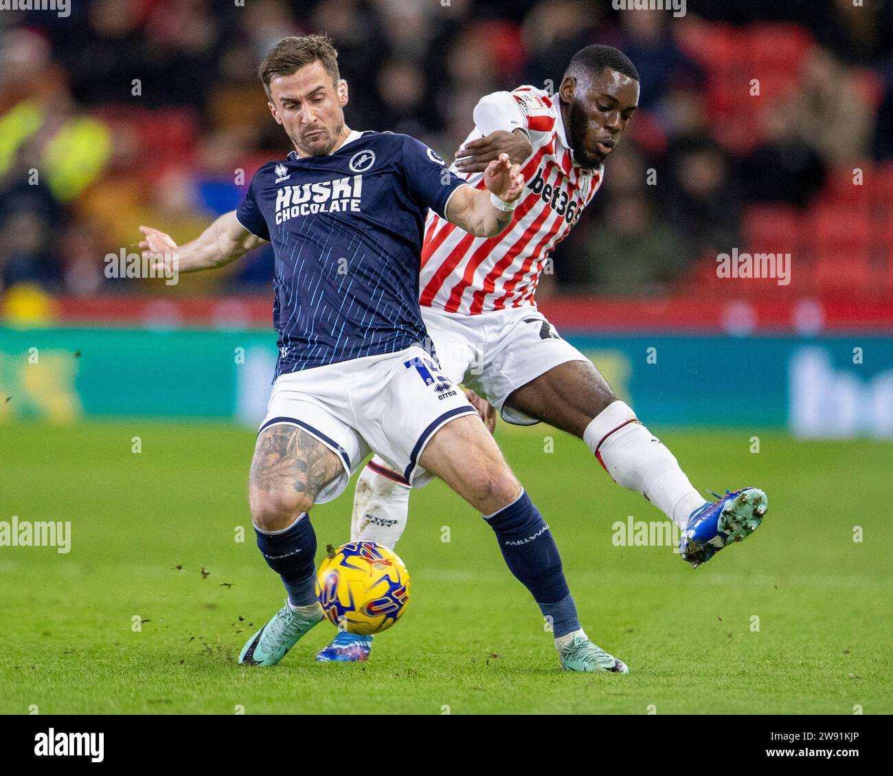 Stoke, Regno Unito. 23 dicembre 2023; Bet365 Stadium, Stoke, Staffordshire, Inghilterra; EFL Championship Football, Stoke City vs Millwall; Joe Bryan di Millwall sotto la pressione di Junior Tchamadeu di Stoke City Credit: Action Plus Sports Images/Alamy Live News Foto Stock