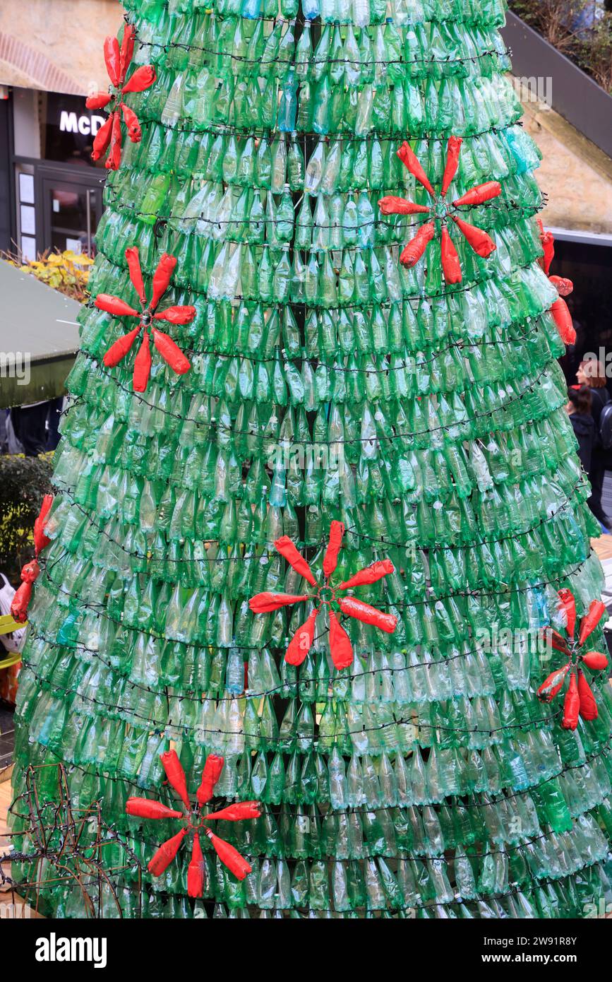 Bordeaux, Francia. 23 dicembre 2023. Ecologia e albero di Natale 100% eco-responsabile. Questo albero di Natale creato con 3000 bottiglie di plastica recuperate aumenta la consapevolezza del consumo eccessivo di plastica che inquina gli oceani e il pianeta. I visitatori sono incoraggiati ad adottare comportamenti più ecologici nella loro vita quotidiana per ridurre o evitare questo inquinamento. Ogni minuto quasi un milione di bottiglie di plastica vengono vendute in tutto il mondo. Foto di Hugo Martin/Alamy Live News. Foto Stock