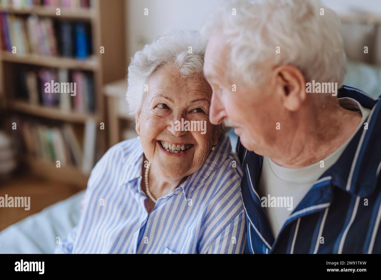 Donna anziana sorridente con un uomo a casa Foto Stock