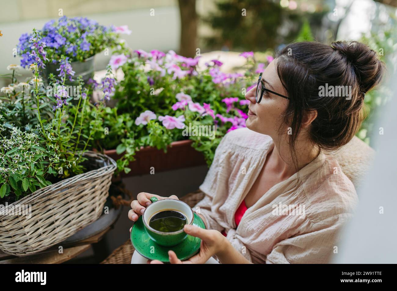 Donna che si gode il tempo libero e una tazza di caffè sul balcone Foto Stock