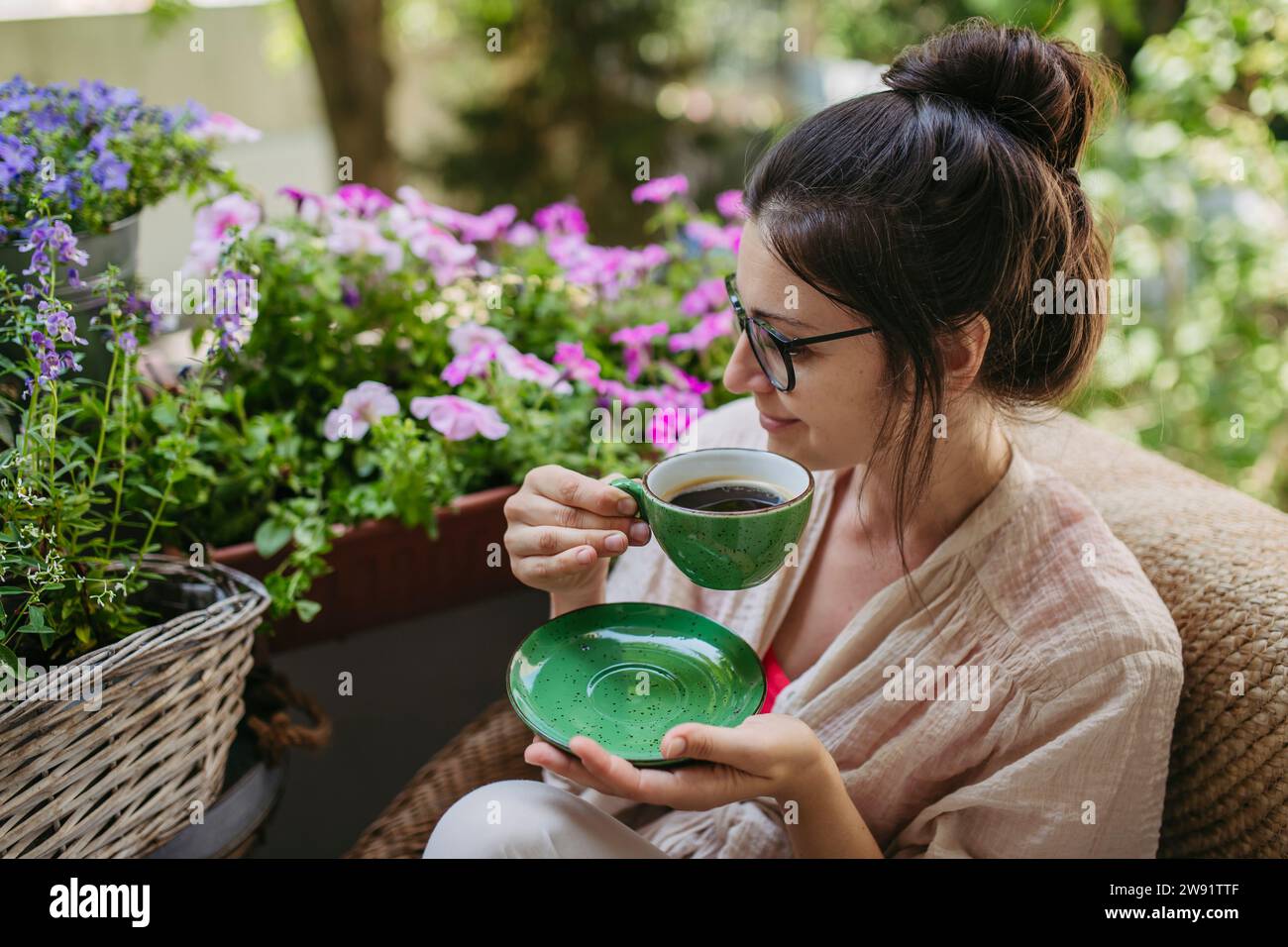 Donna che si gode il tempo libero e una tazza di caffè sul balcone Foto Stock