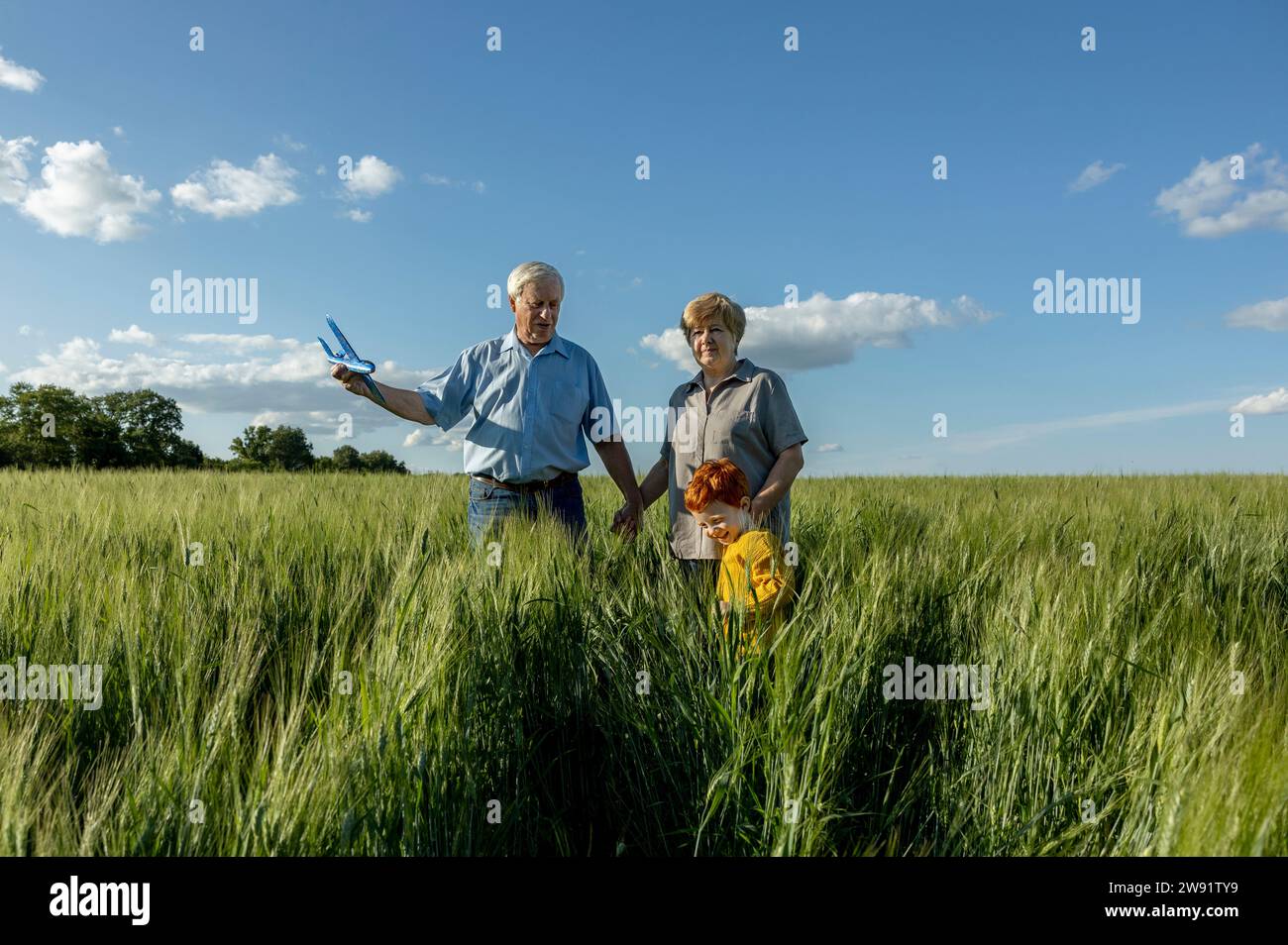 Coppia anziana che si diverte con il nipote sul campo Foto Stock