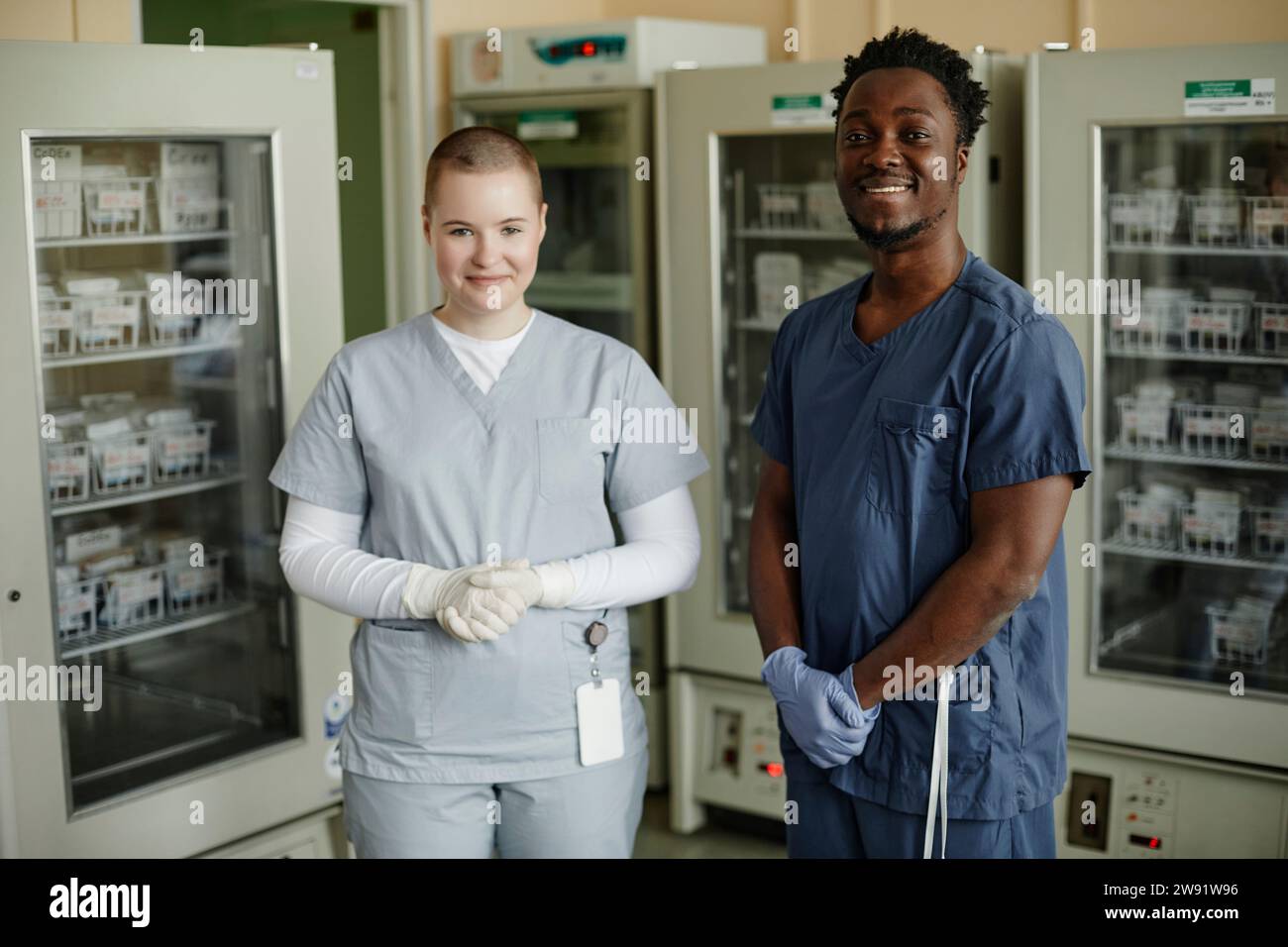 Lavoratori medici sorridenti in piedi insieme al centro di donazione del sangue Foto Stock