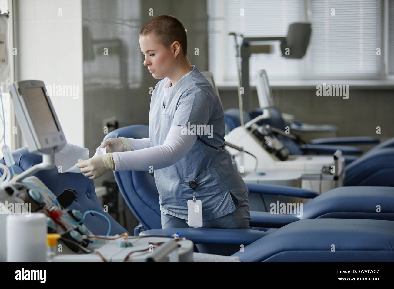 Operatore sanitario che prepara il divano al centro di donazione del sangue Foto Stock