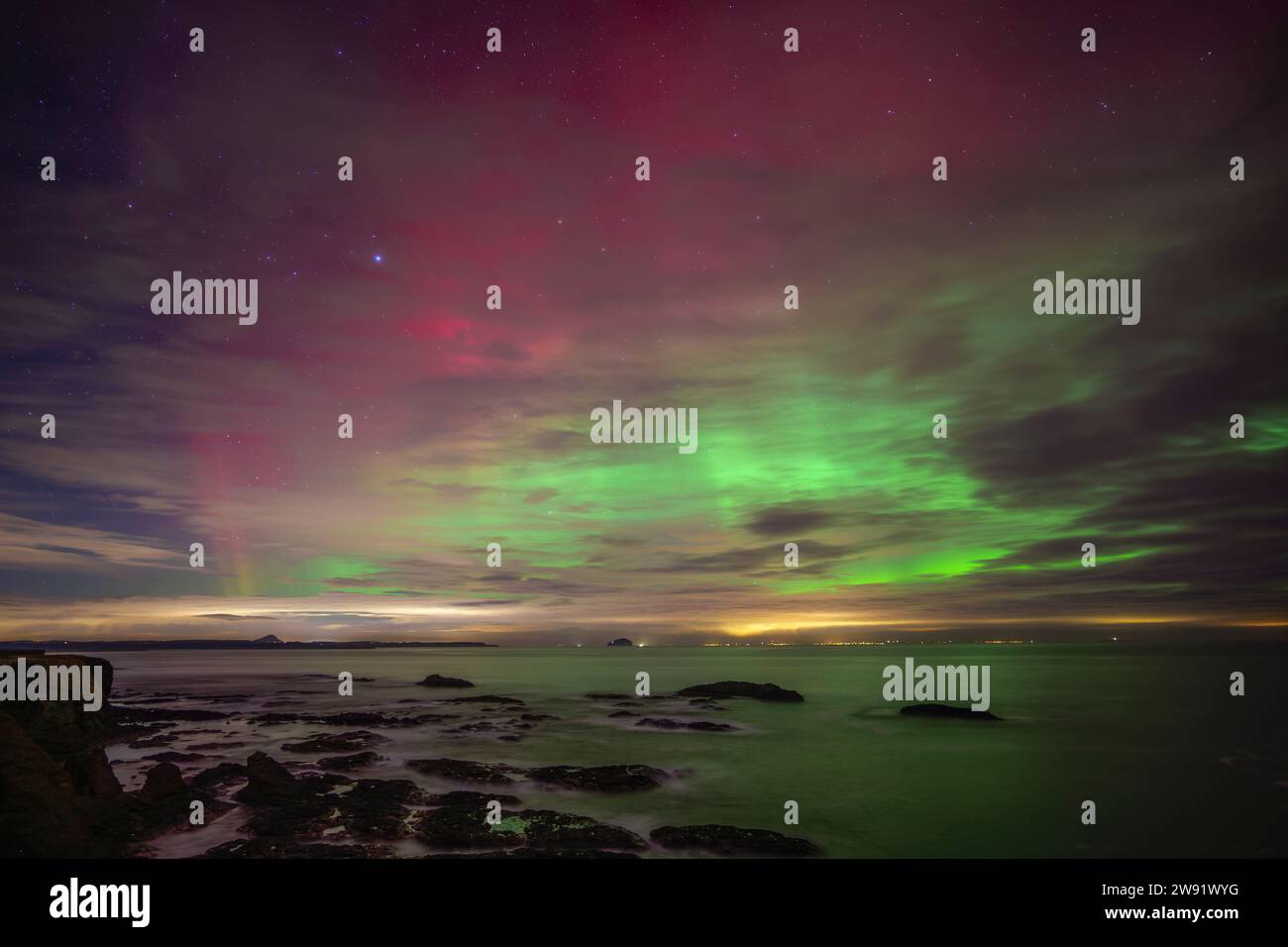 Regno Unito, Scozia, Dunbar, lunga esposizione di aurora boreale su Firth of Forth di notte Foto Stock