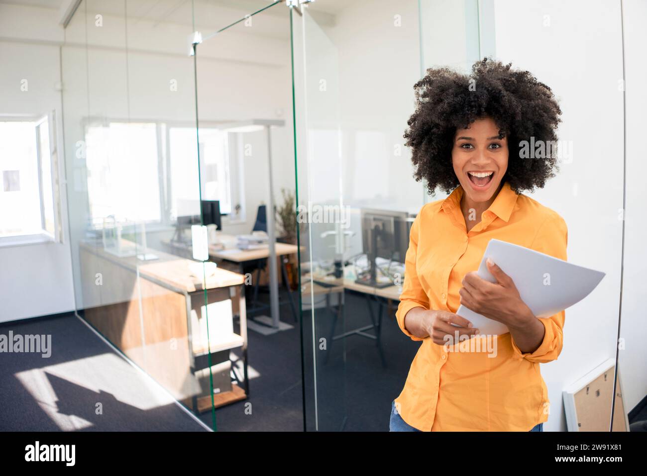 Donna d'affari con la bocca aperta e un documento in ufficio Foto Stock