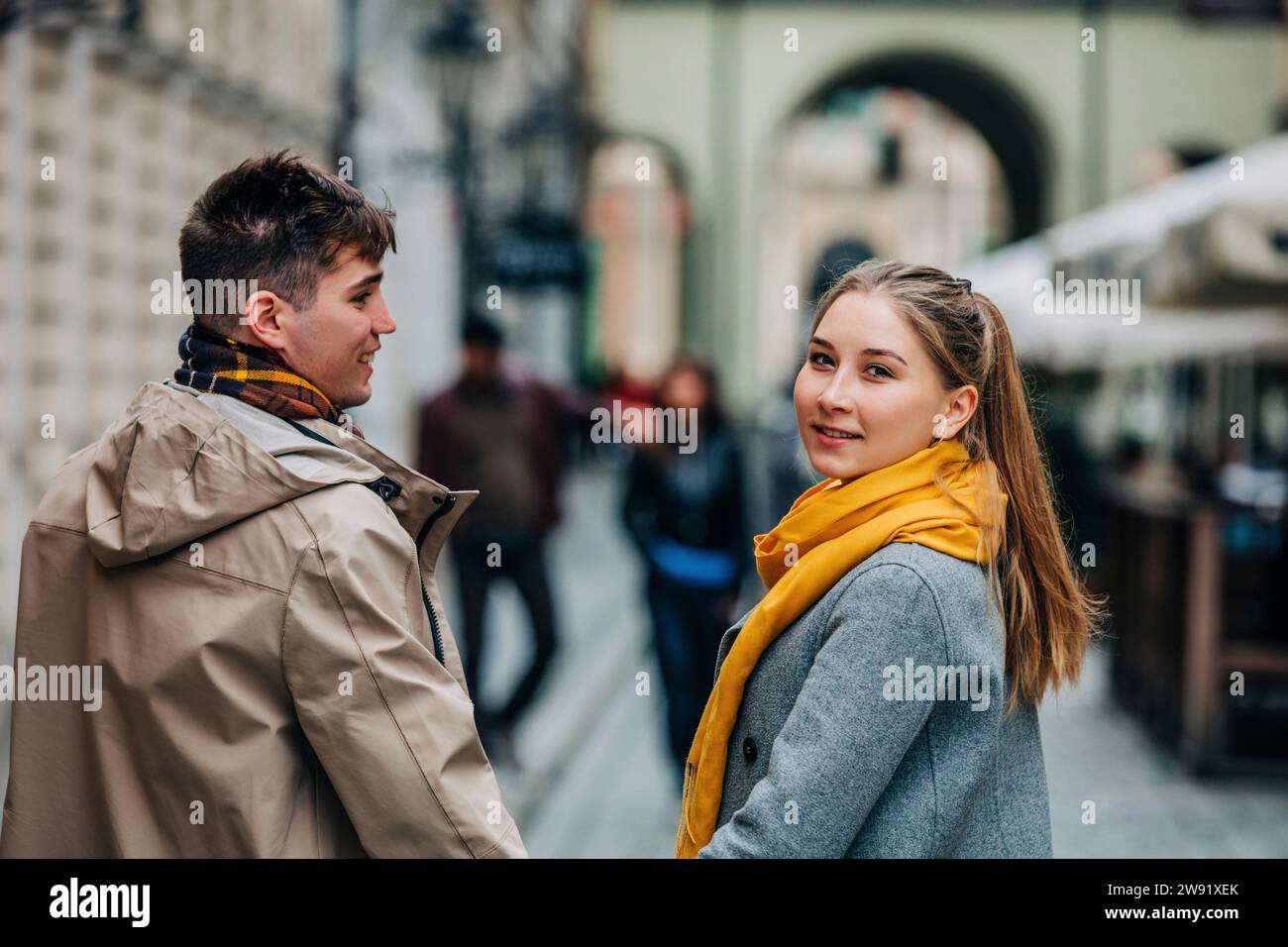 Donna che guarda alle spalle con il fidanzato in strada Foto Stock