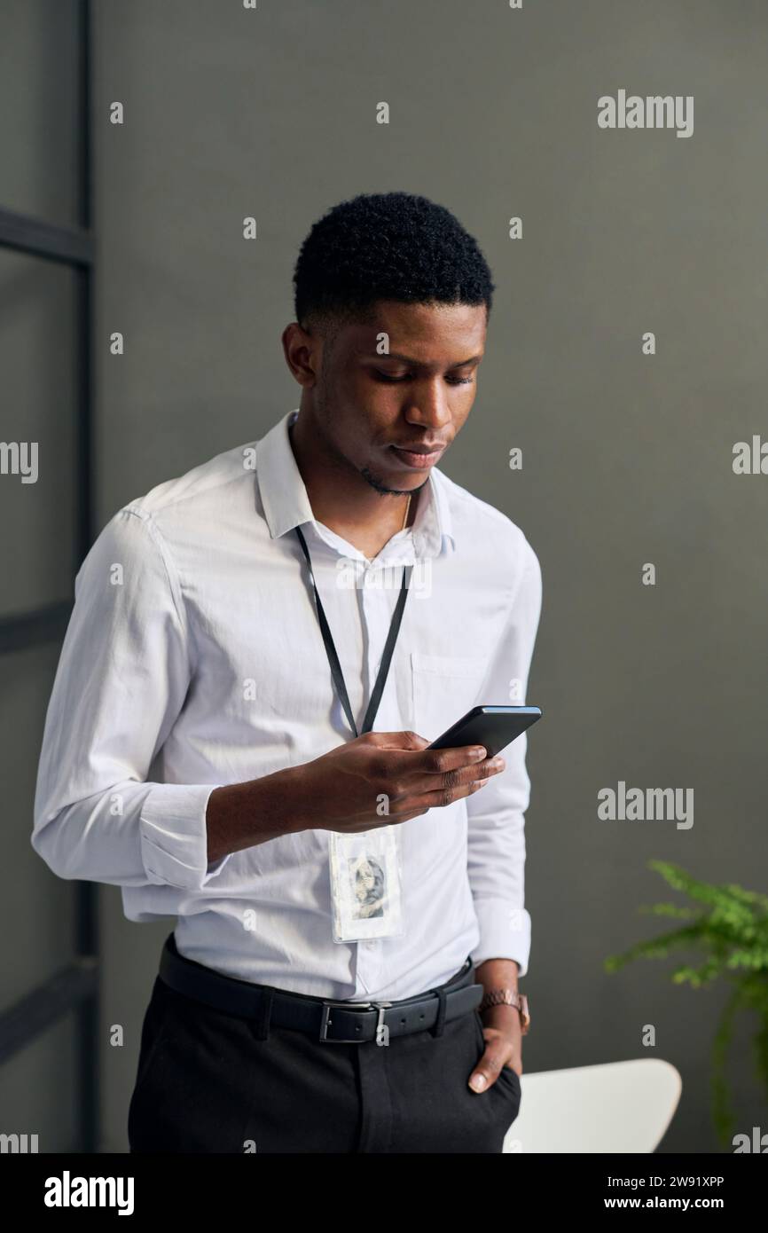 Giovane imprenditore utilizzando smart phone in office Foto Stock