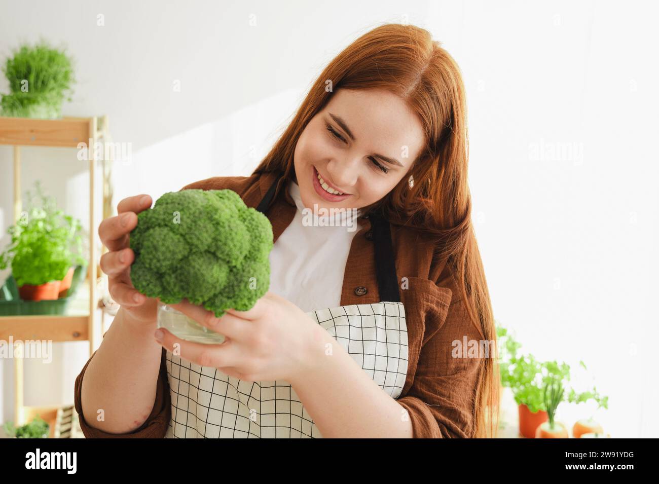 Un botanico sorridente che esamina i broccoli a casa Foto Stock