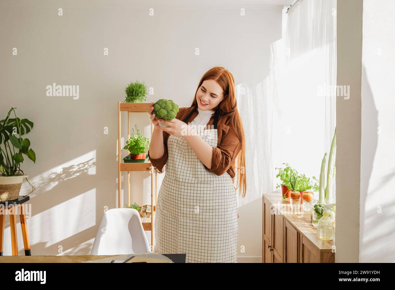 Botanico sorridente che esamina i broccoli a casa Foto Stock
