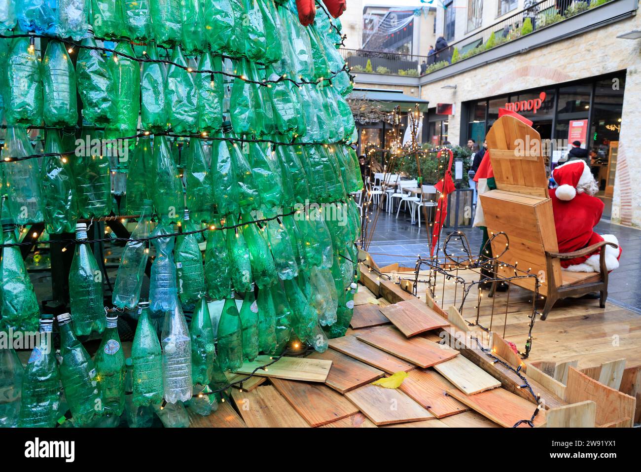 Bordeaux, Francia. 23 dicembre 2023. Ecologia e albero di Natale 100% eco-responsabile. Questo albero di Natale creato con 3000 bottiglie di plastica recuperate aumenta la consapevolezza del consumo eccessivo di plastica che inquina gli oceani e il pianeta. I visitatori sono incoraggiati ad adottare comportamenti più ecologici nella loro vita quotidiana per ridurre o evitare questo inquinamento. Ogni minuto quasi un milione di bottiglie di plastica vengono vendute in tutto il mondo. Foto di Hugo Martin/Alamy Live News. Foto Stock