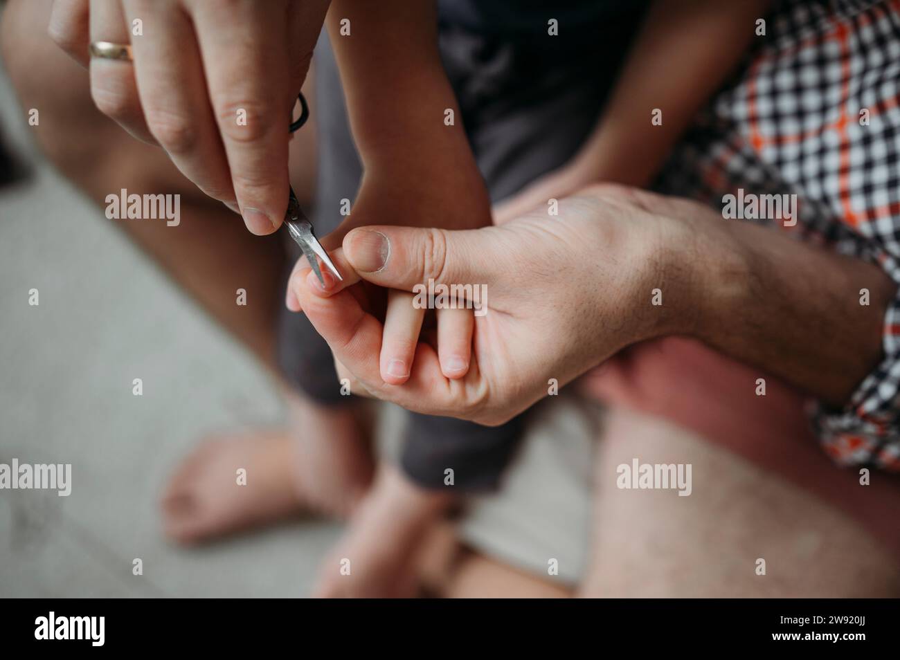 Padre che taglia le unghie del figlio a casa Foto Stock